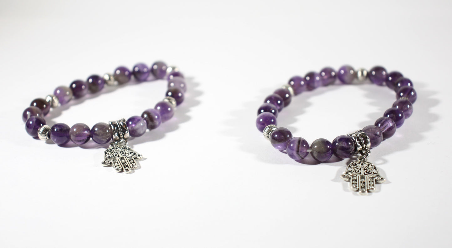 Two amethyst stretchy bracelet with pendant. Kaksi eri kokoista ametisti joustavaa rannekorua hamsa hand riipuksella.
