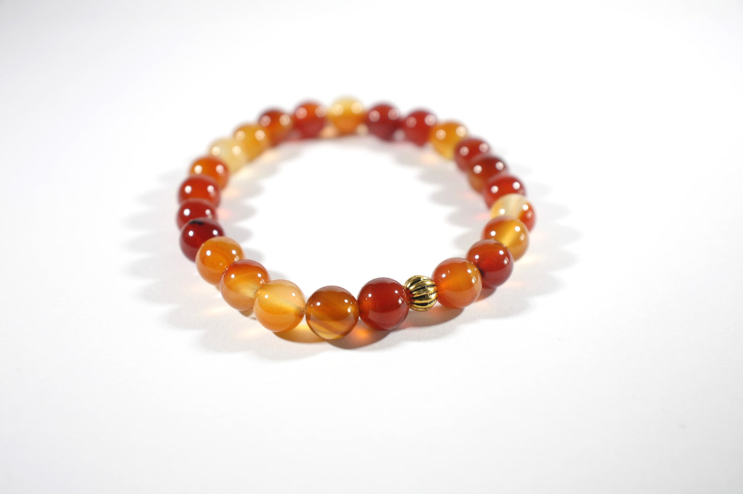 Agate orange tones stretch bracelet with gold color bead. Akaatti jousto rannekoru lämpimän oranssin sävyissä. Korussa on yksi kullan värinen korumetalli helmi.