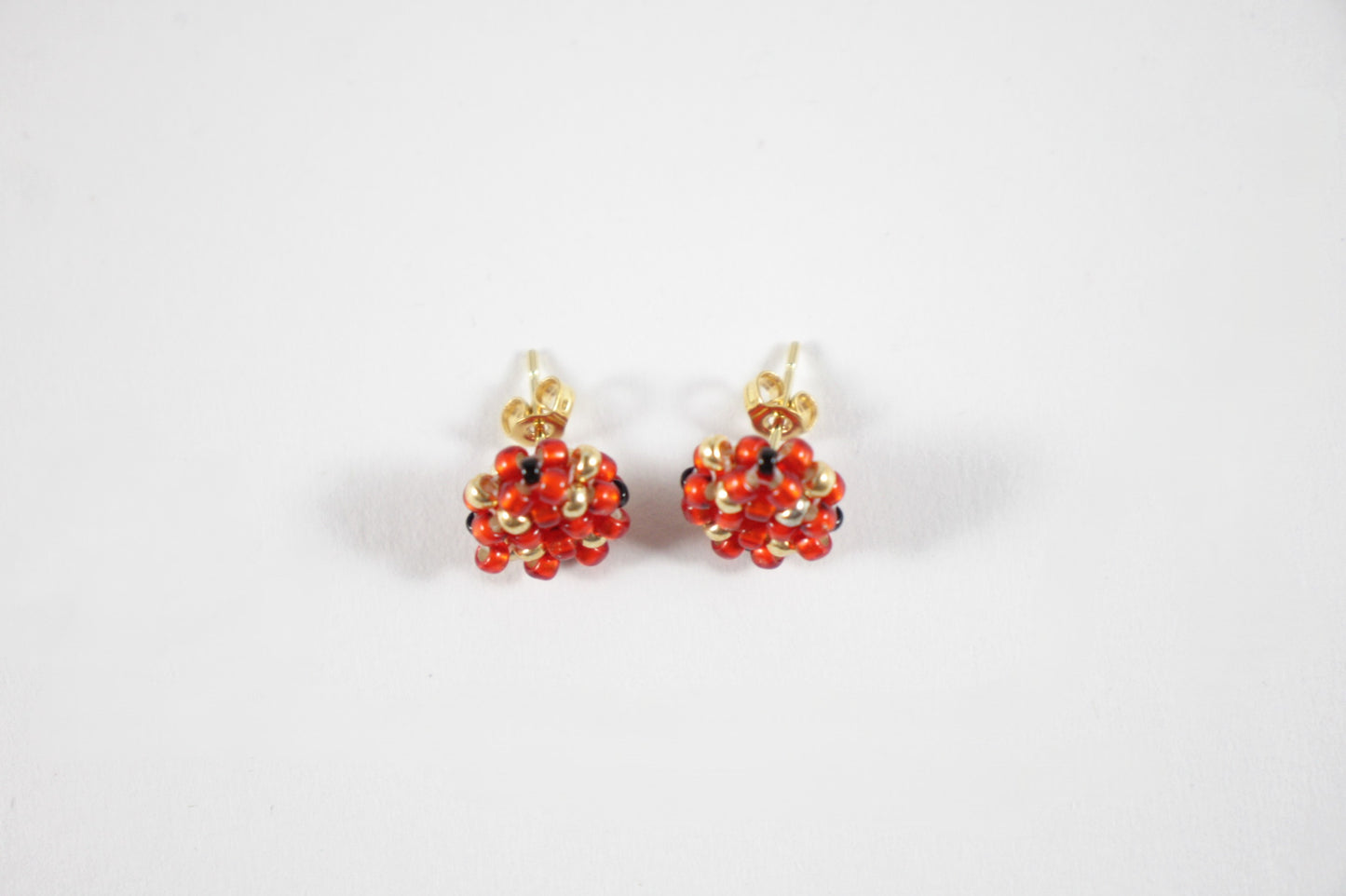 Beaded glass bead red-gold stud earrings. Käsintehdyt puna-kultaiset nappihelmikorvakorut.