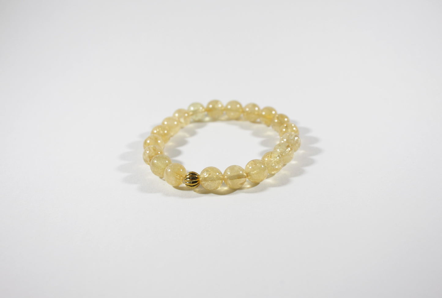Yellow citrine stretch bracelet with one gold color bead. Keltainen sitriini joustorannekoru yhdellä kullanvärisellä helmellä.