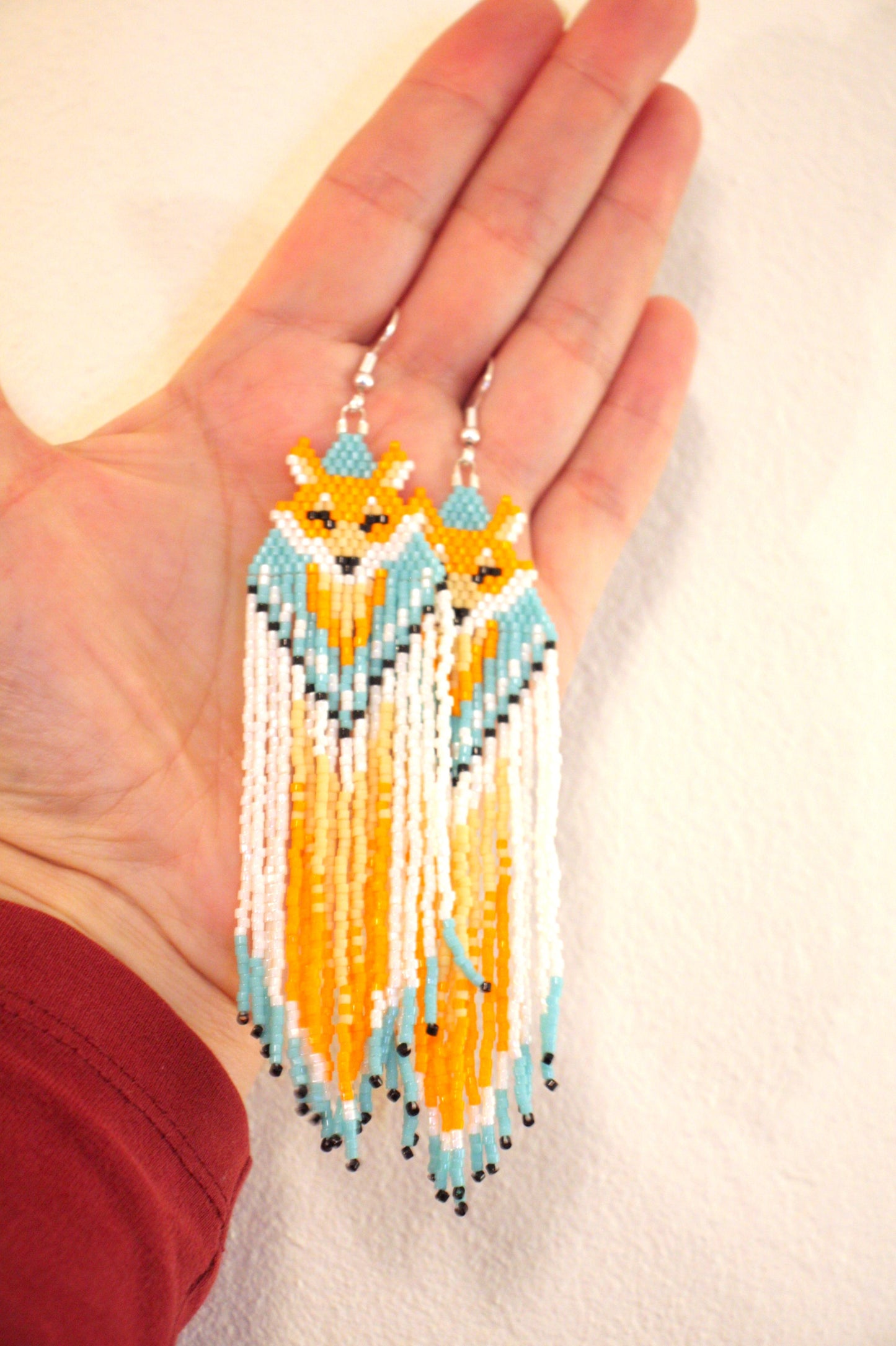 Hapsulliset lasihelmikorvakorut ketut värinä oranssi-siniturkoosi. Seed bead fringe earrings foxes, color orange and blueturquoise.