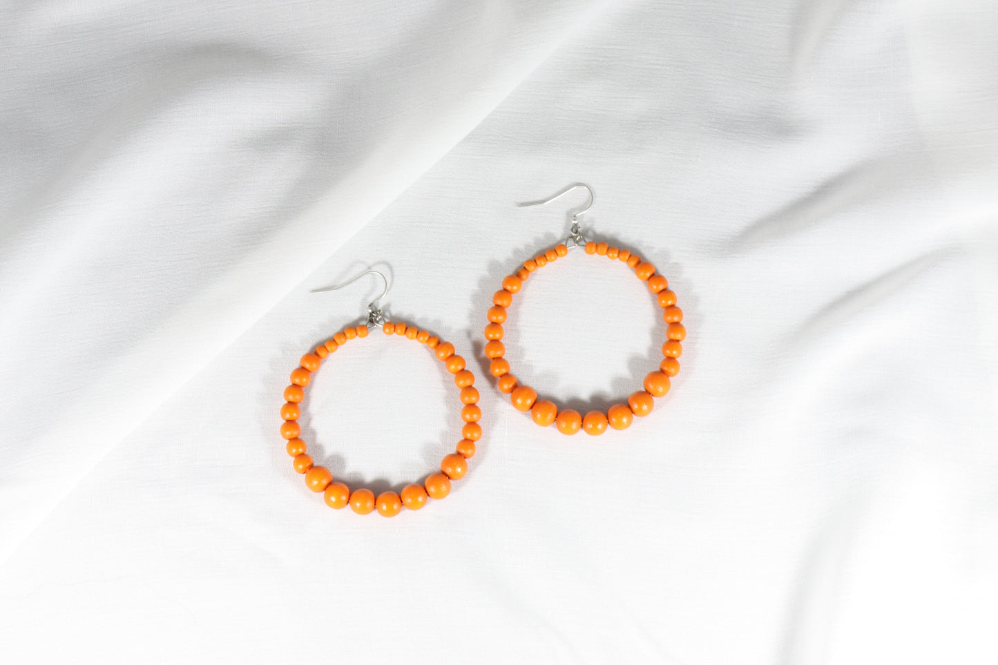 Oranssit puuhelmirengaskorvakorut. Orange wooden bead hoop earrings.