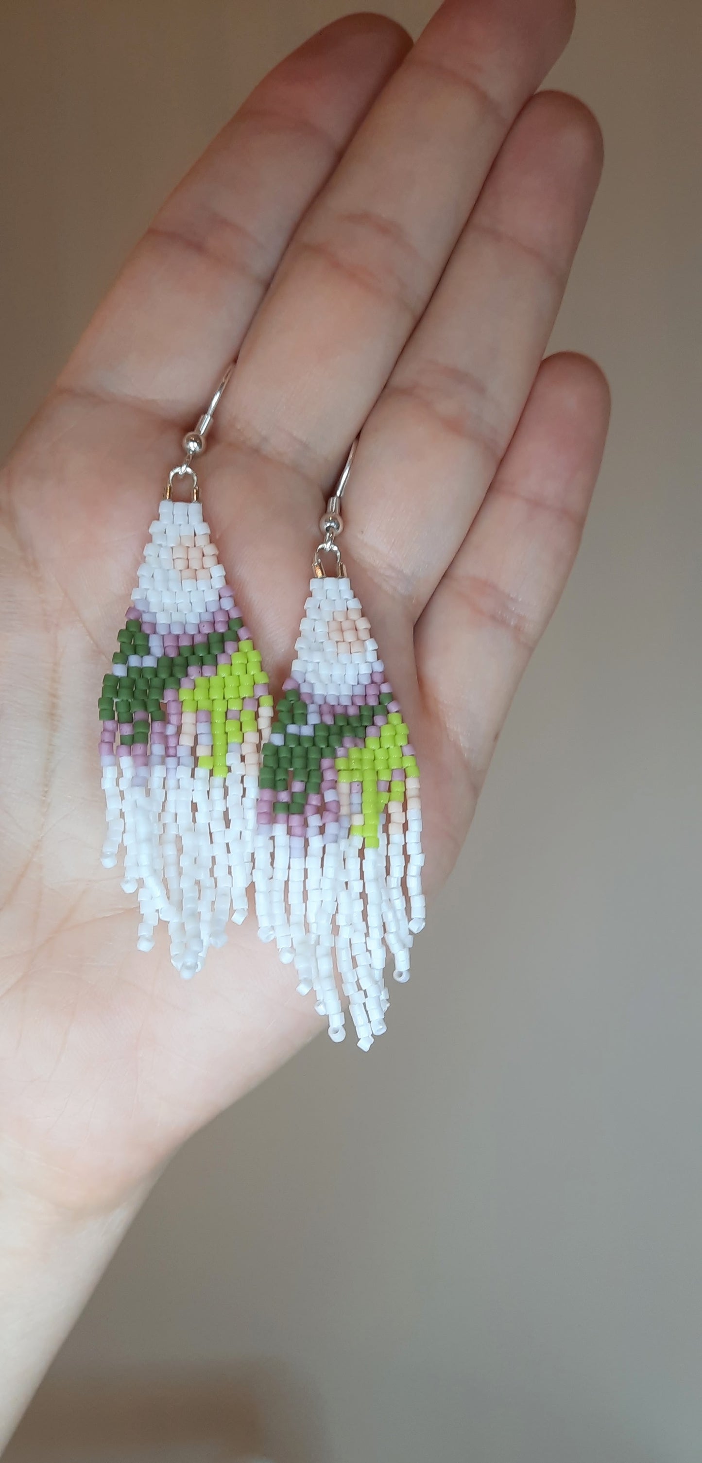 Colorful seed bead fringe earrings with landscape pattern. These earrings has white base color. Roikkuvat värikkäät lasihelmi korvakorut maisemakuviolla. Näissä koruissa on valkoinen pohjaväri.