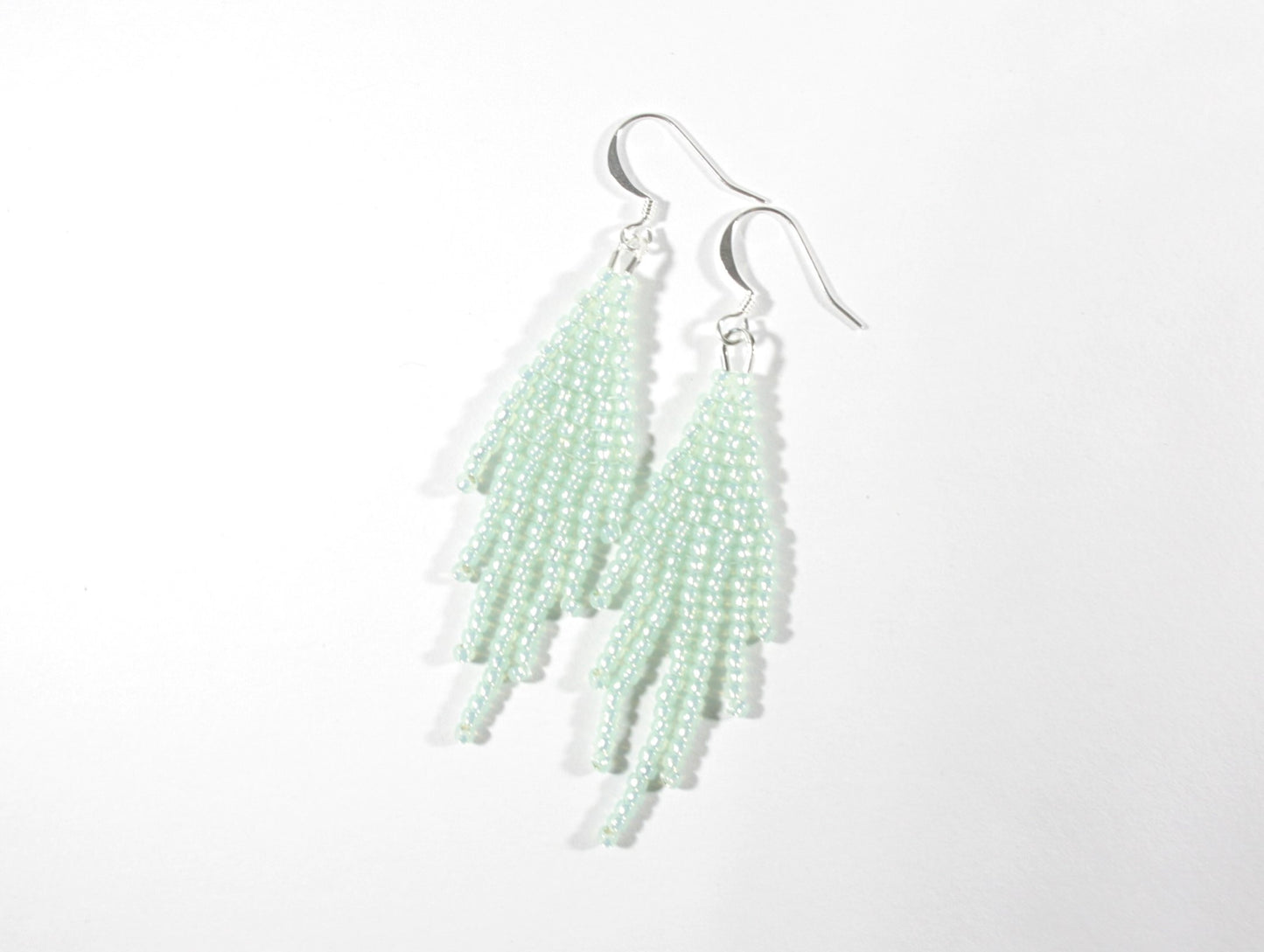 Seed bead fringe earrings small, color is sparkling light mint green. Hooks are silver color jewelry metal. Hapsulliset lasihelmikorvakorut pienet, väriltään vaalea vihreä minttu. Koukut ovat hopean väristä korumetallia.