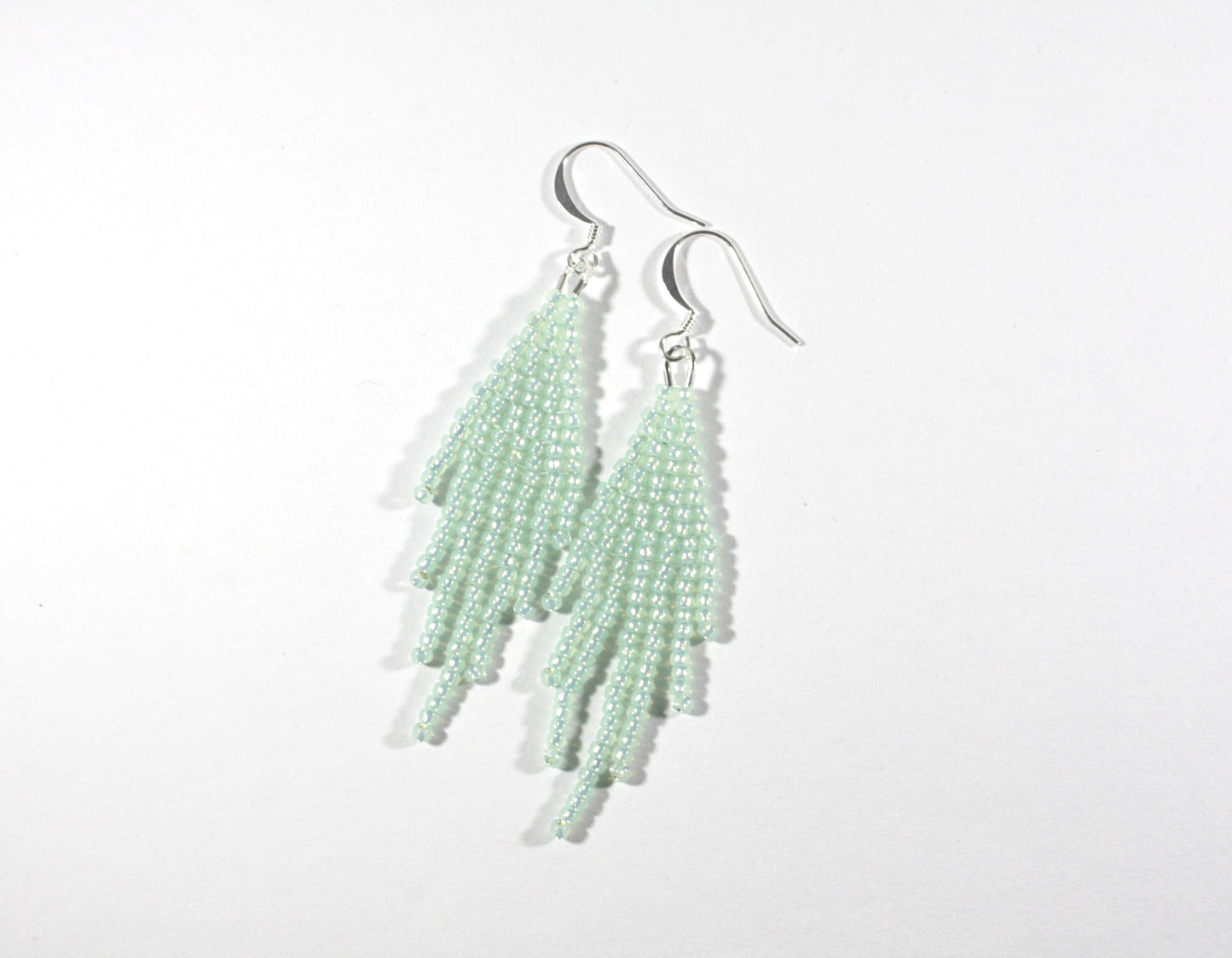 Seed bead fringe earrings small, color is sparkling light mint green. Hooks are silver color jewelry metal. Hapsulliset lasihelmikorvakorut pienet, väriltään vaalea vihreä minttu. Koukut ovat hopean väristä korumetallia.
