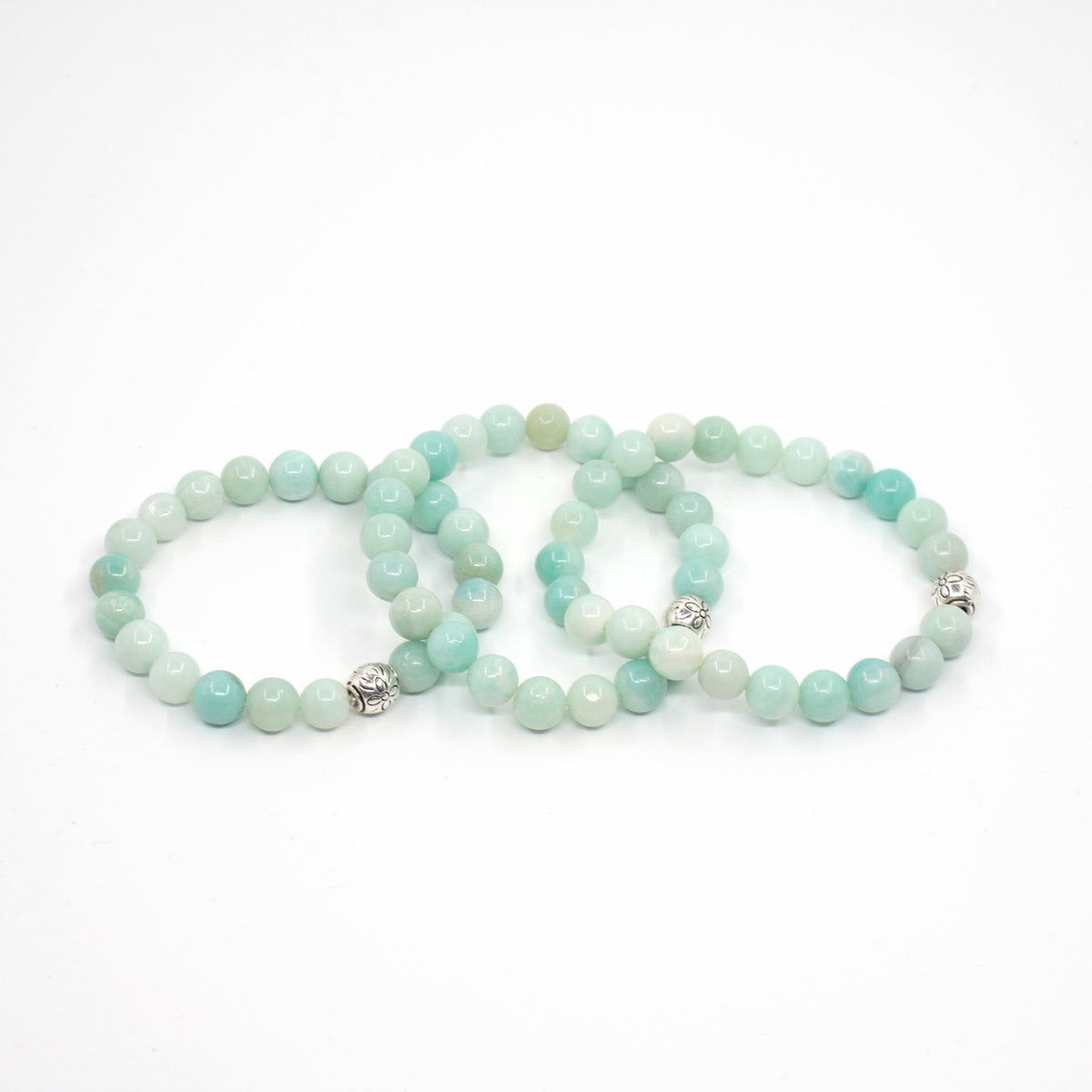 Kolme amatsoniitti rannekorua valkoisella alustalla. Three amazonite bracelets on a white surface. 