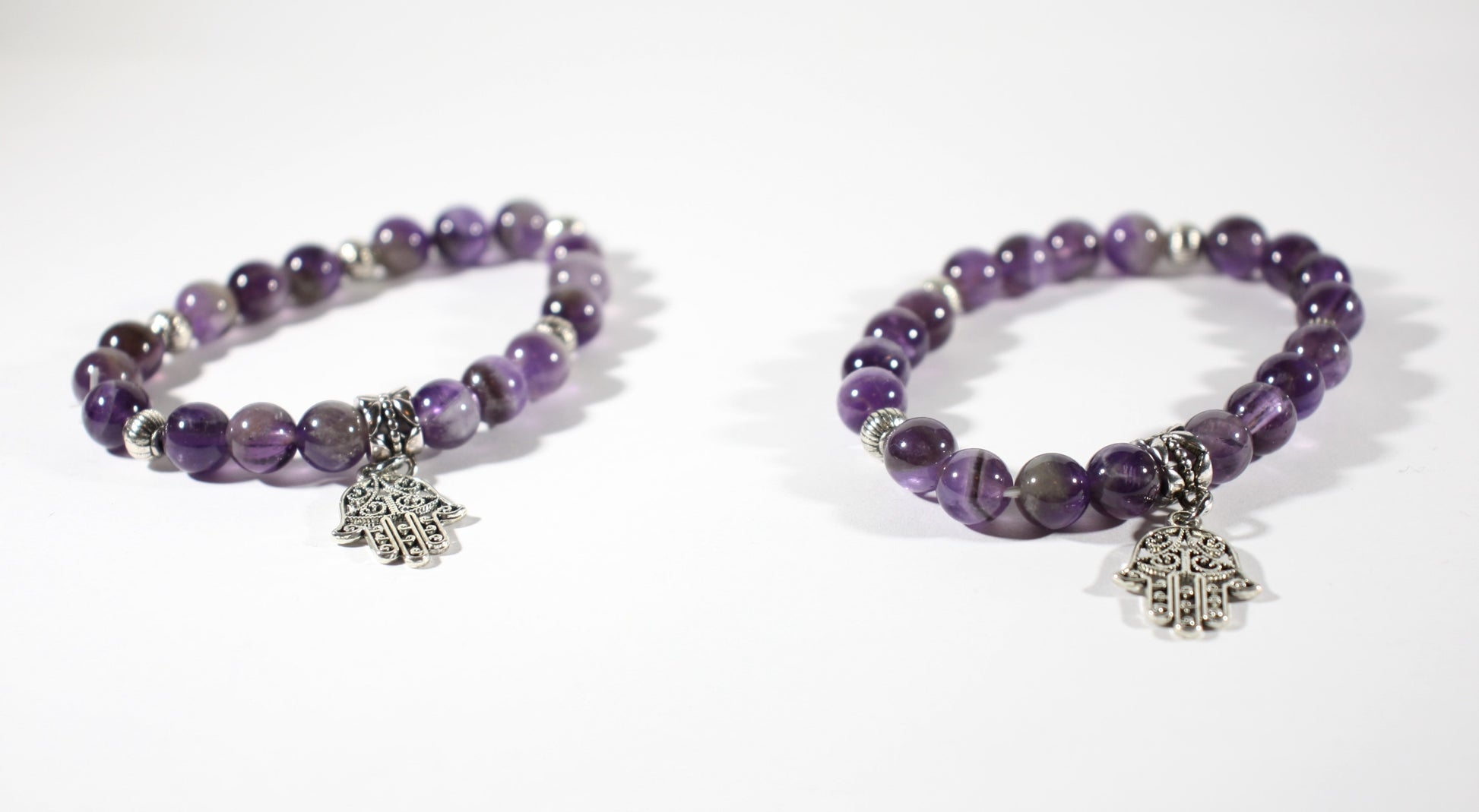 
Two amethyst stretchy bracelet with pendant. Kaksi eri kokoista ametisti joustavaa rannekorua hamsa hand riipuksella.