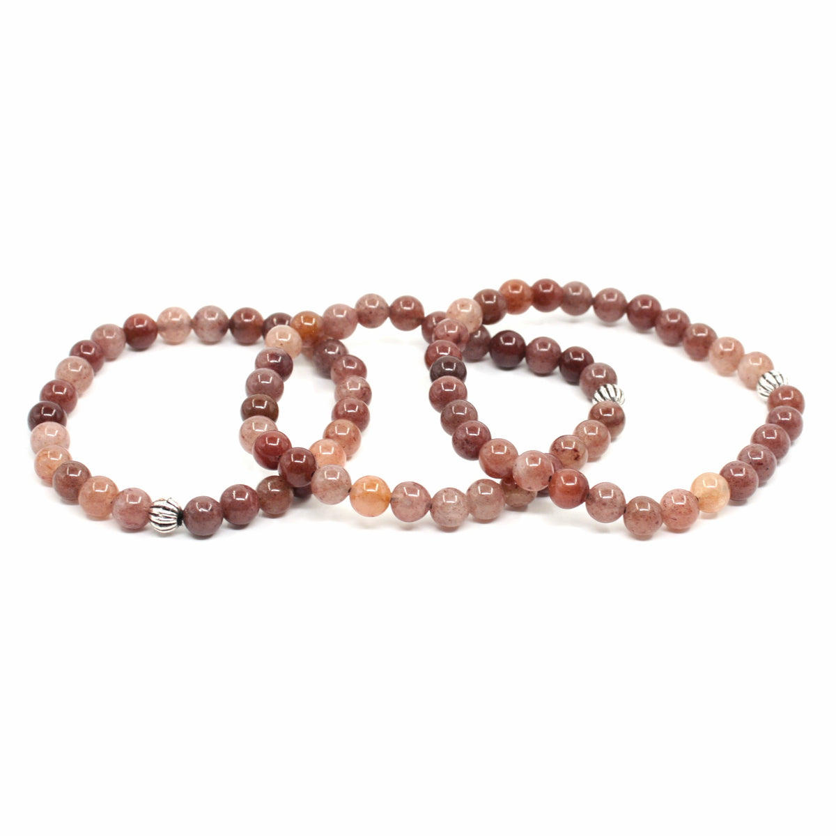 Kolme aventuriini rannekorua valkoisella alustalla. Three aventurine stretchy bracelets on the white surface.