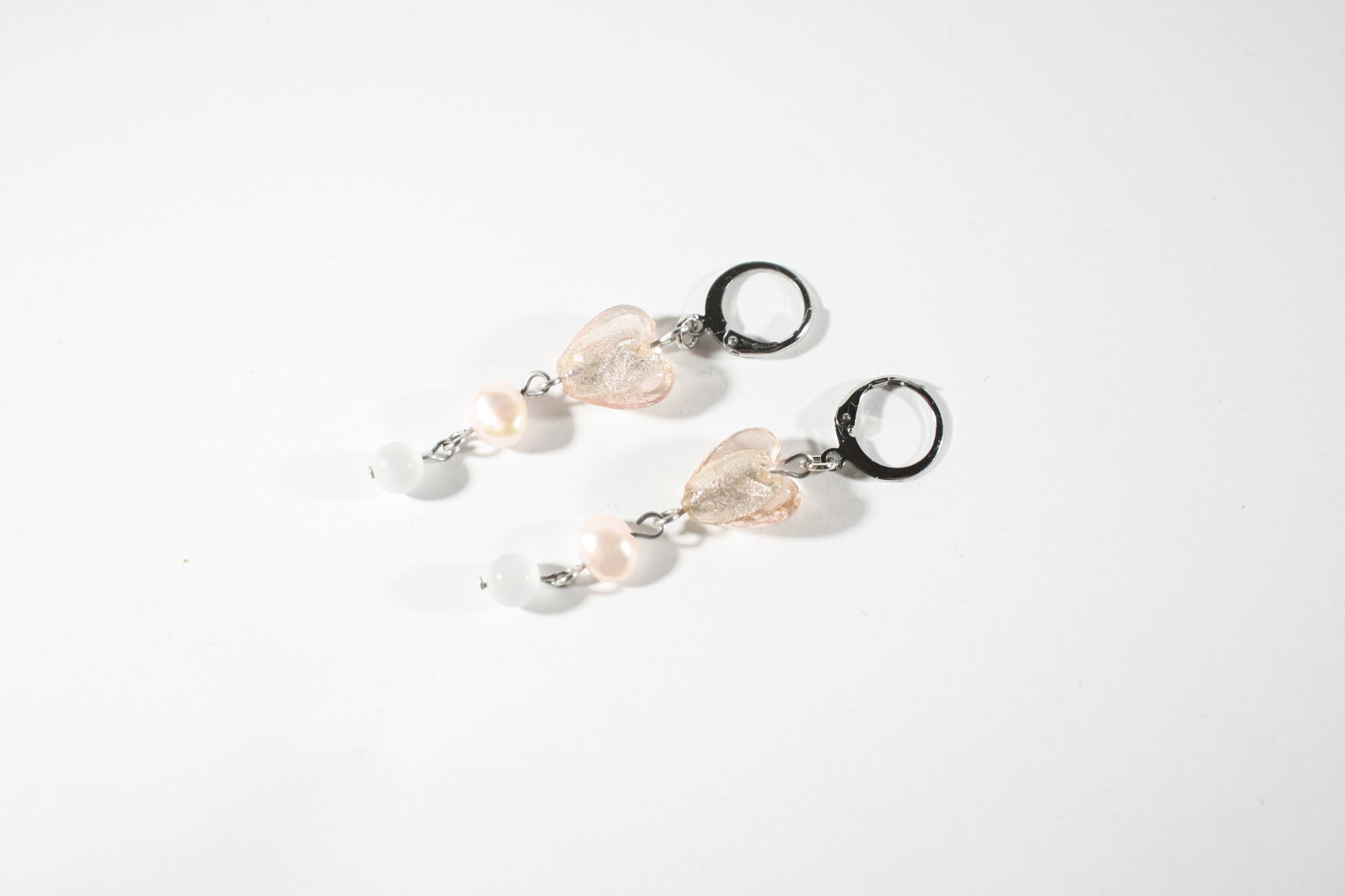 Dangle pink heart glass bead freshwaterpearl earrings. Roikkuva lasihelmikorvakoru makeanveden helmellä. Ihana vaaleanpunainen lasisydän tuo näihin koruihin herkkyyttä.