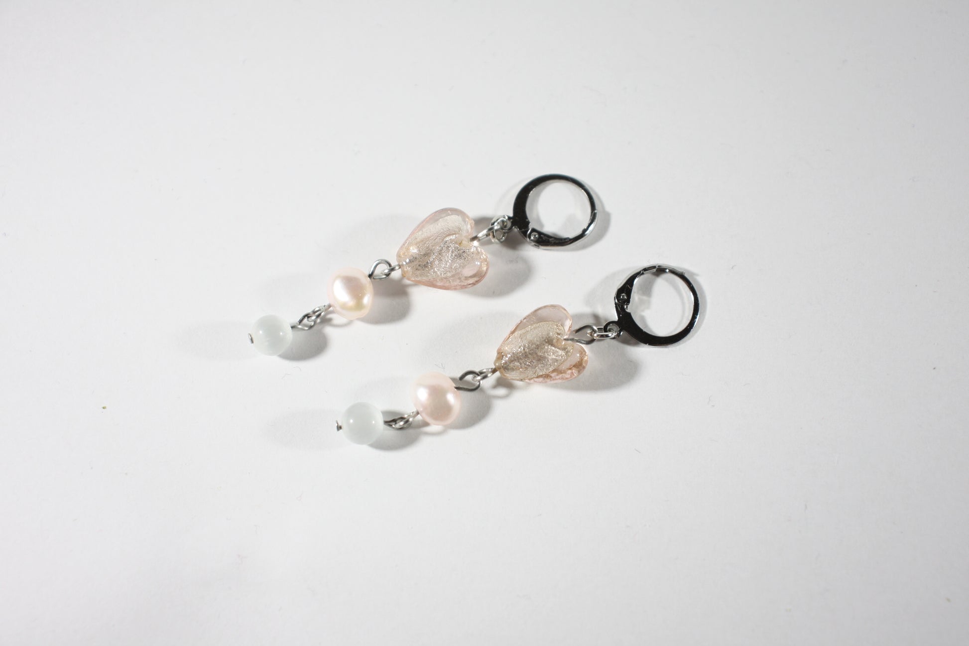 Dangle pink heart glass bead freshwaterpearl earrings. Roikkuva lasihelmikorvakoru makeanveden helmellä. Ihana vaaleanpunainen lasisydän tuo näihin koruihin herkkyyttä.