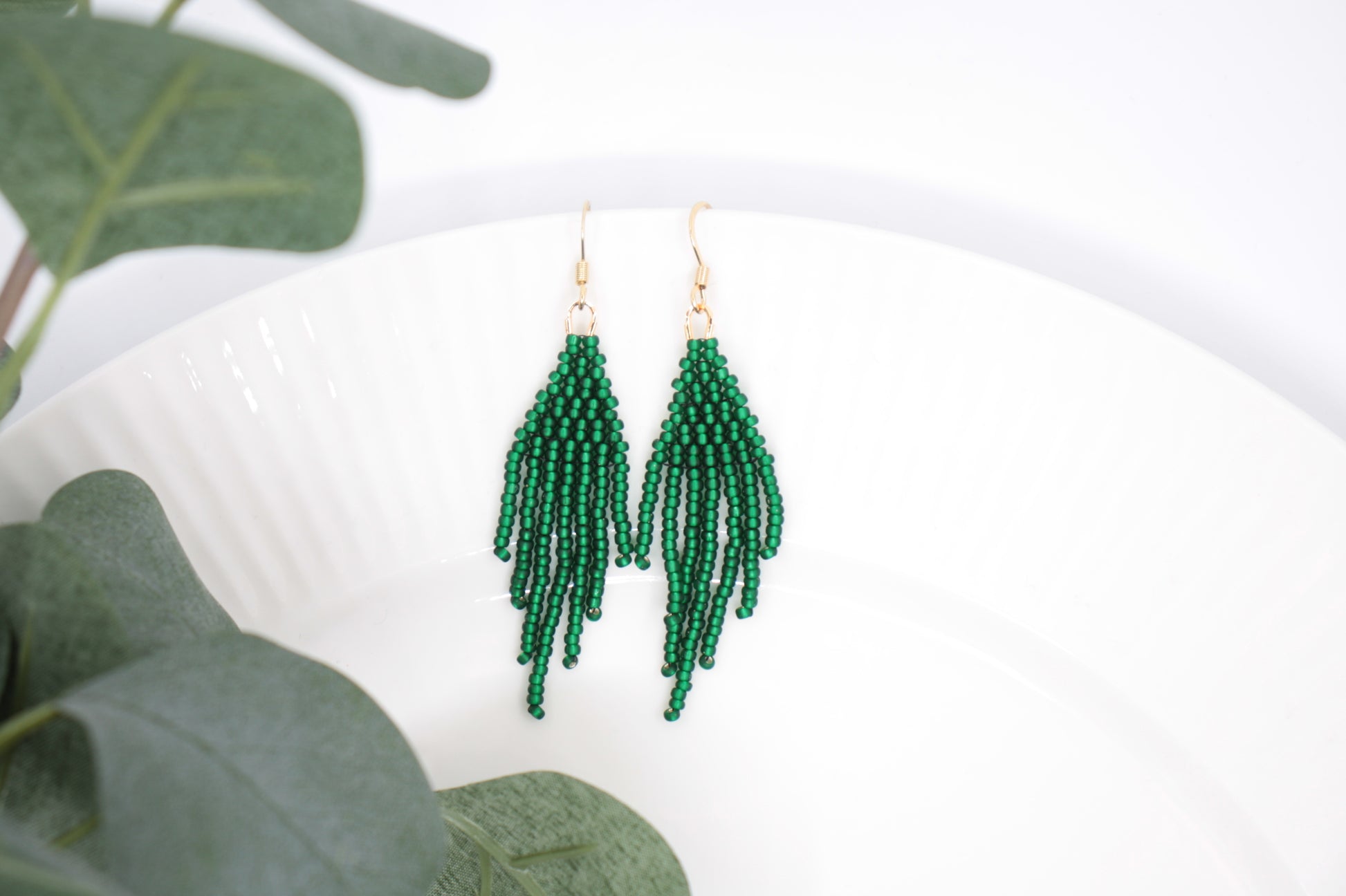 Hapsulliset helmikorvakorut valkoisella alustalla. Korvakorujen väri on matta vihreä. Seed bead fringe earrings on white background. Earrings color is matte green. 