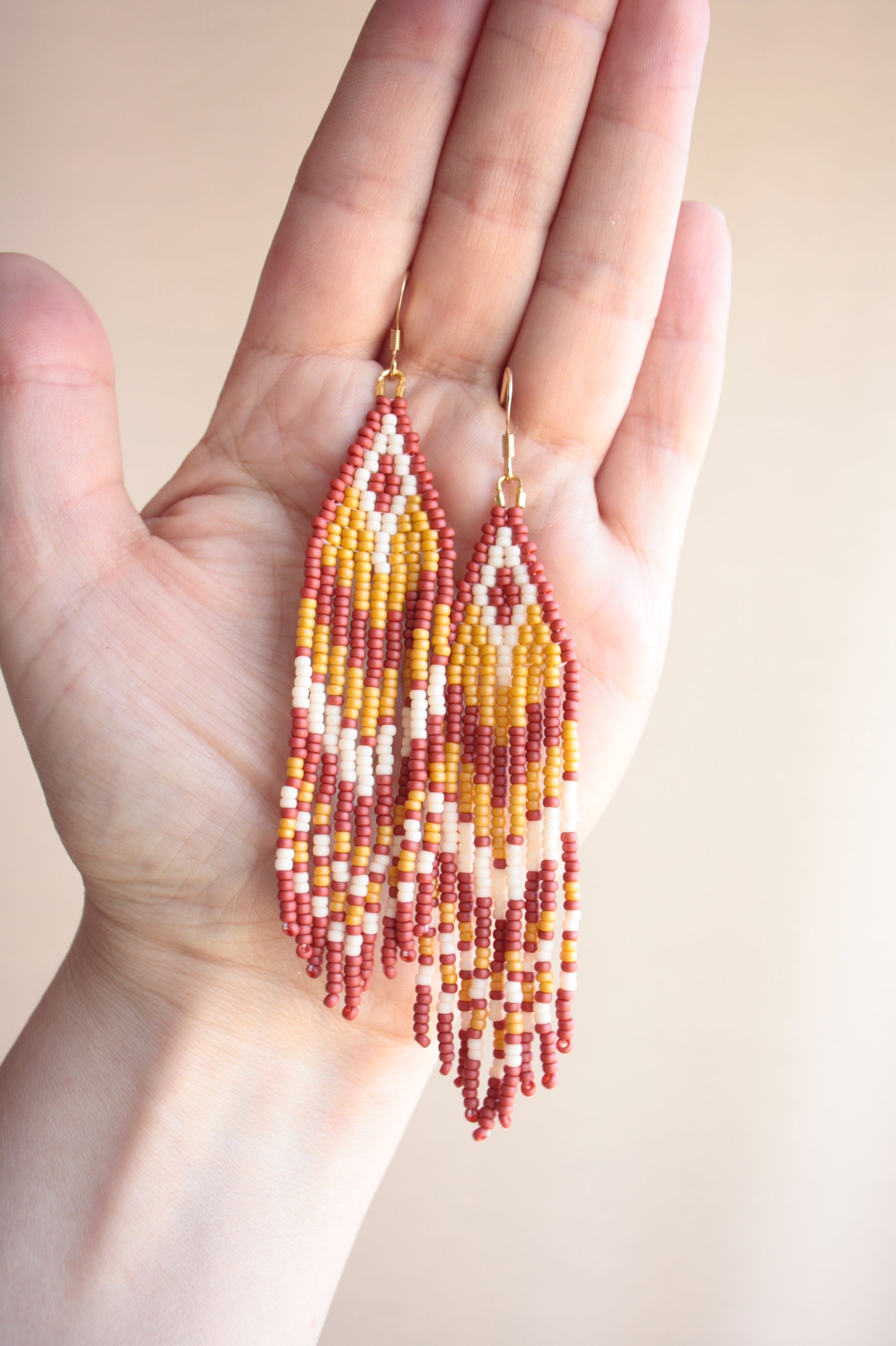 Roikkuvat hapsulliset raidalliset helmikorvakorut lasihelmillä ruskean sävyissä. Beaded seed bead striped fringe earrings in shades of brown.