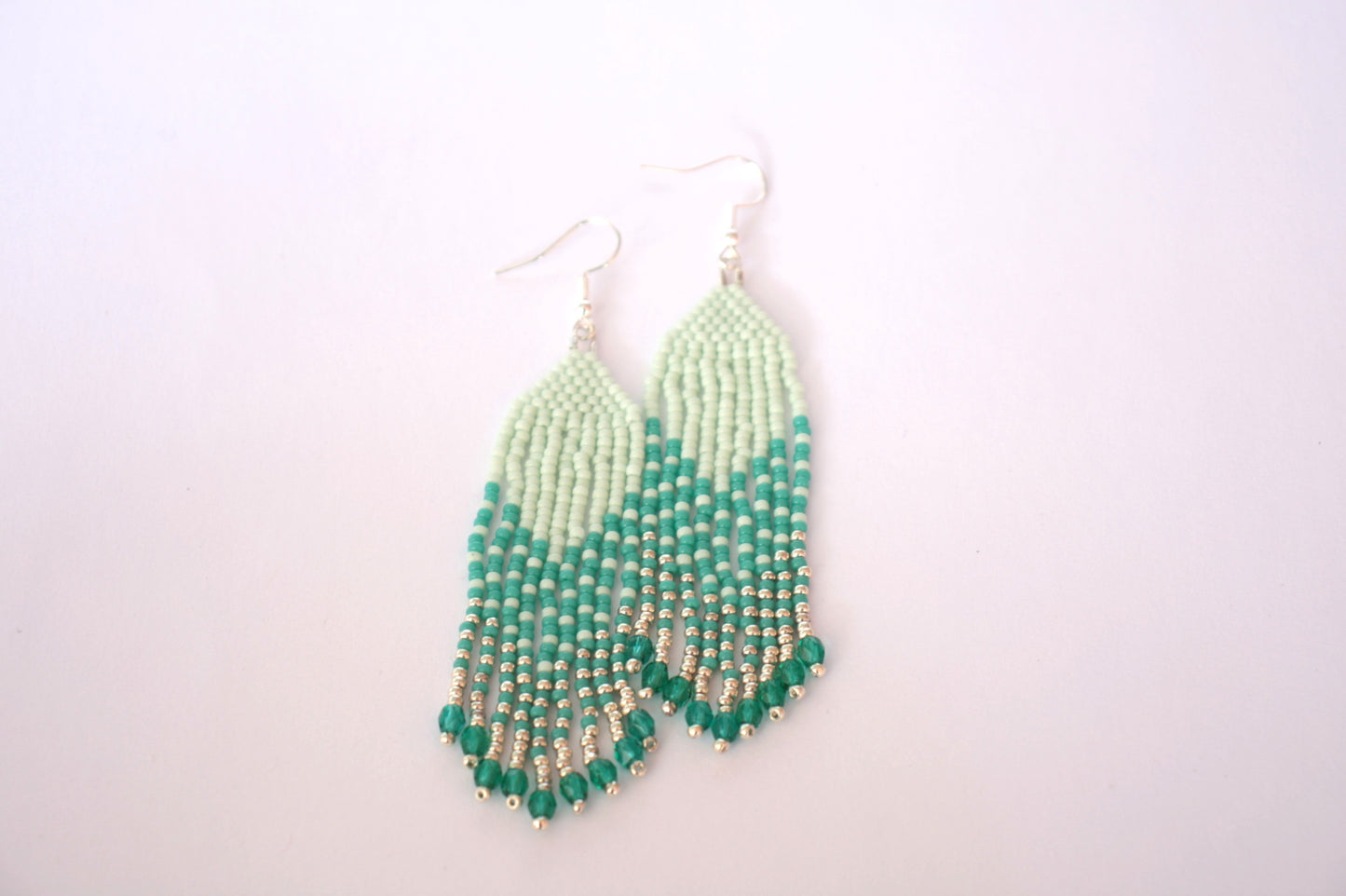 Hapsulliset kotimaiset roikkuvat helmikorvakorut mintun ja turkoosin sävyissä. Beaded seed bead fringe earrings with mint and turquoise colors.