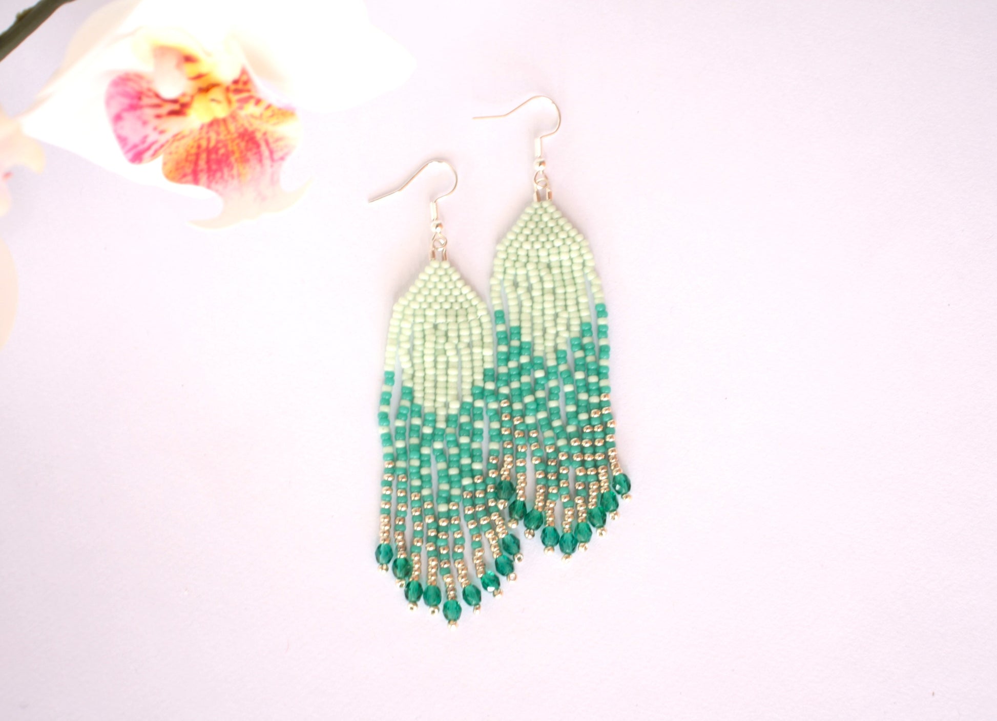Hapsulliset kotimaiset roikkuvat helmikorvakorut mintun ja turkoosin sävyissä. Beaded seed bead fringe earrings with mint and turquoise colors.