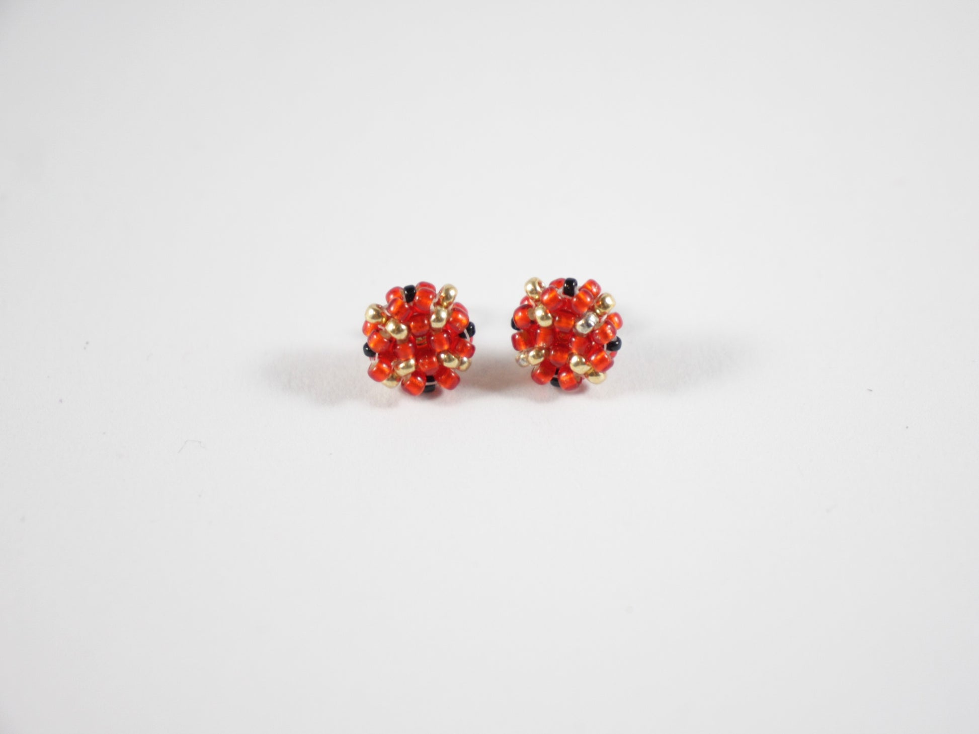 Beaded glass bead red-gold stud earrings. Käsintehdyt puna-kultaiset nappihelmikorvakorut.
