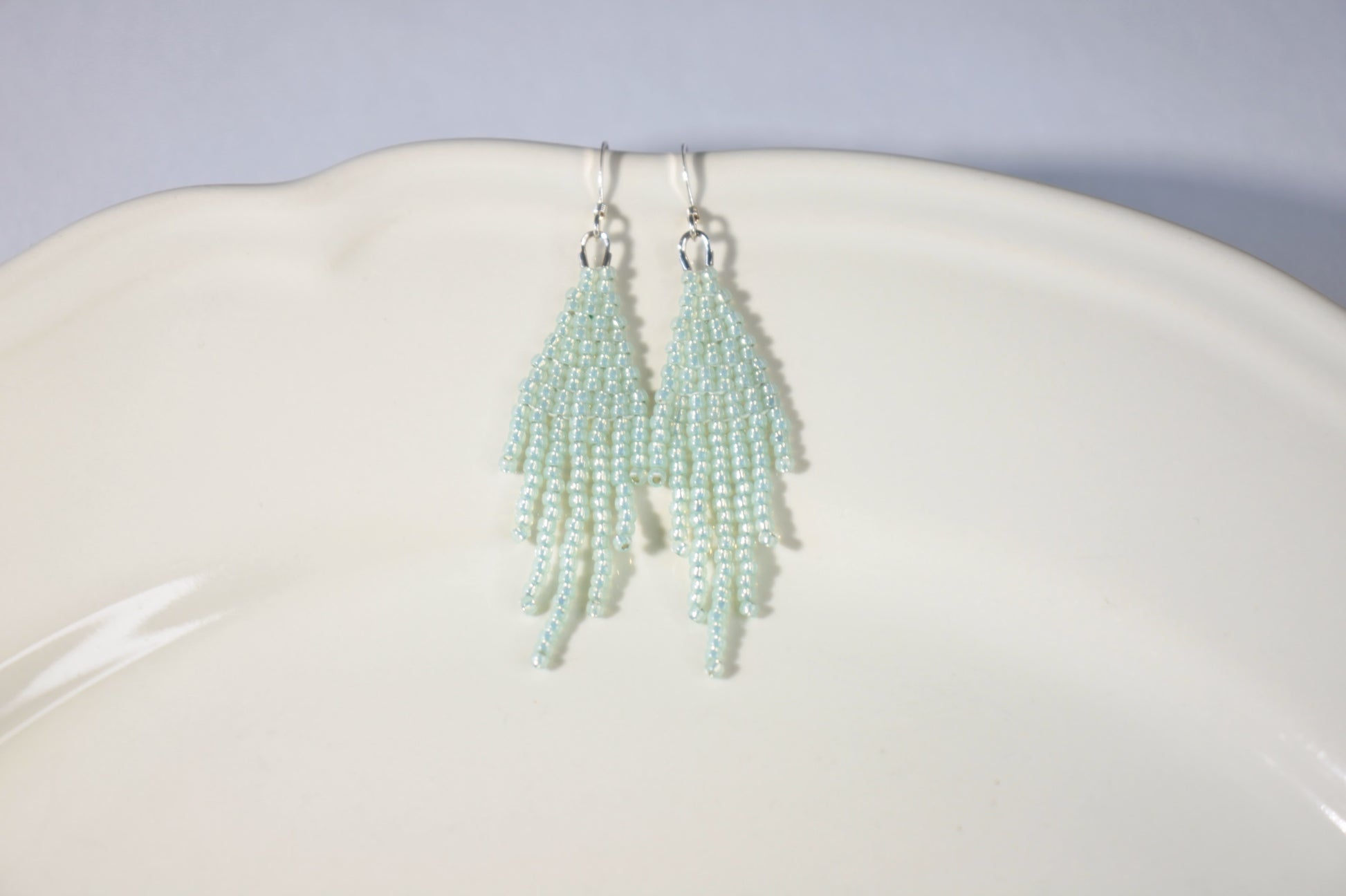 Seed bead fringe earrings small, color is sparkling light mint green. Hooks are silver color jewelry metal. Hapsulliset lasihelmikorvakorut pienet, väriltään vaalea vihreä minttu. Koukut ovat hopean väristä korumetallia. 