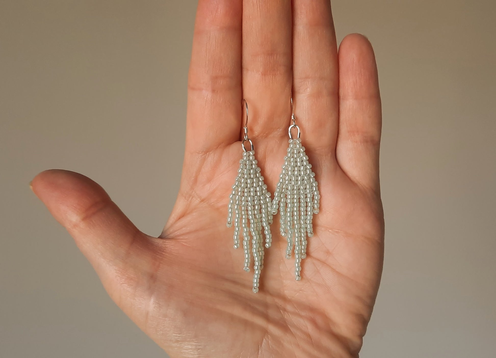 Seed bead fringe earrings small, color is sparkling light mint green. Hooks are silver color jewelry metal. Hapsulliset lasihelmikorvakorut pienet, väriltään vaalea vihreä minttu. Koukut ovat hopean väristä korumetallia. 