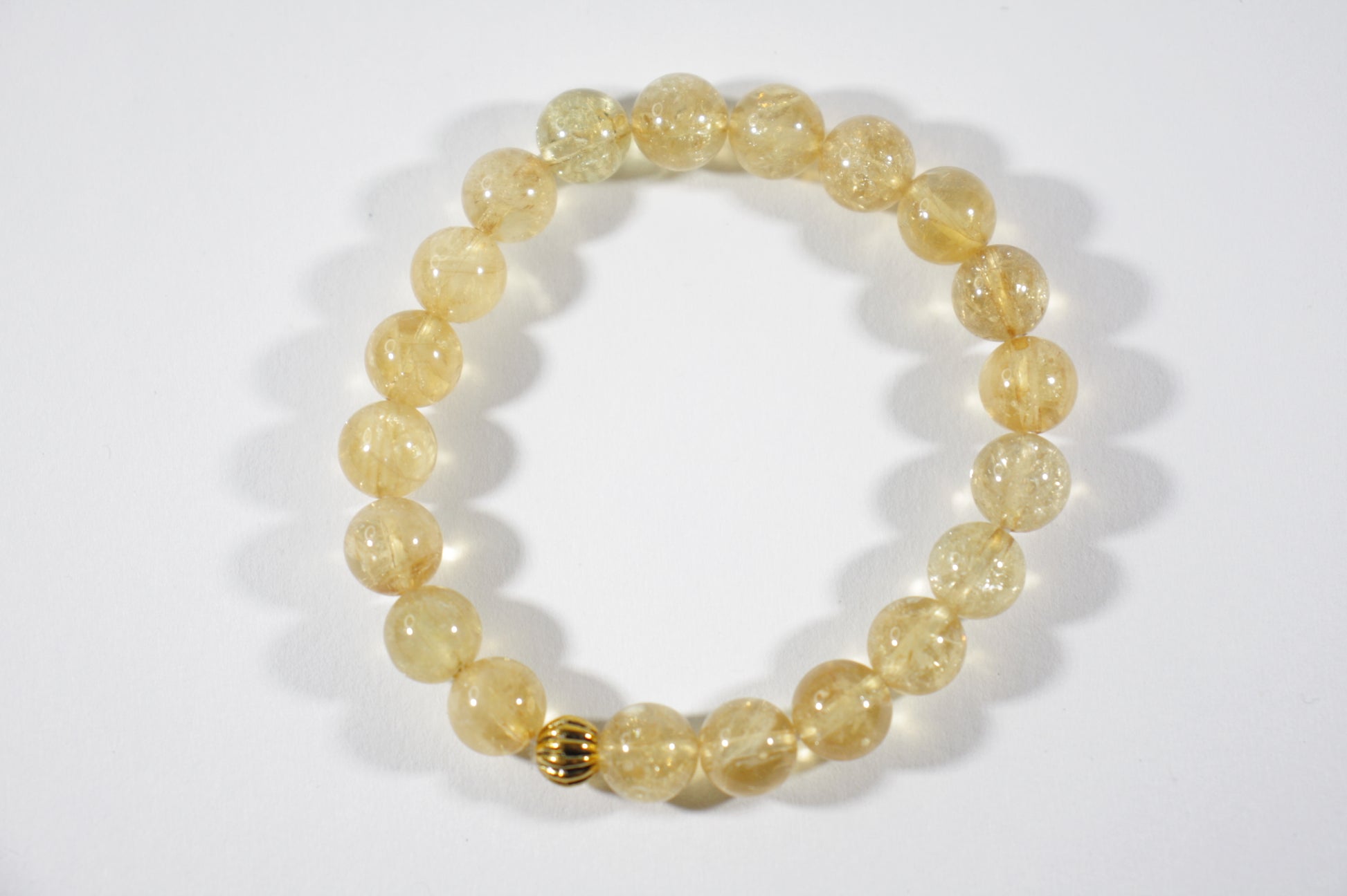 Yellow citrine stretch bracelet with one gold color bead. Keltainen sitriini joustorannekoru yhdellä kullanvärisellä helmellä.