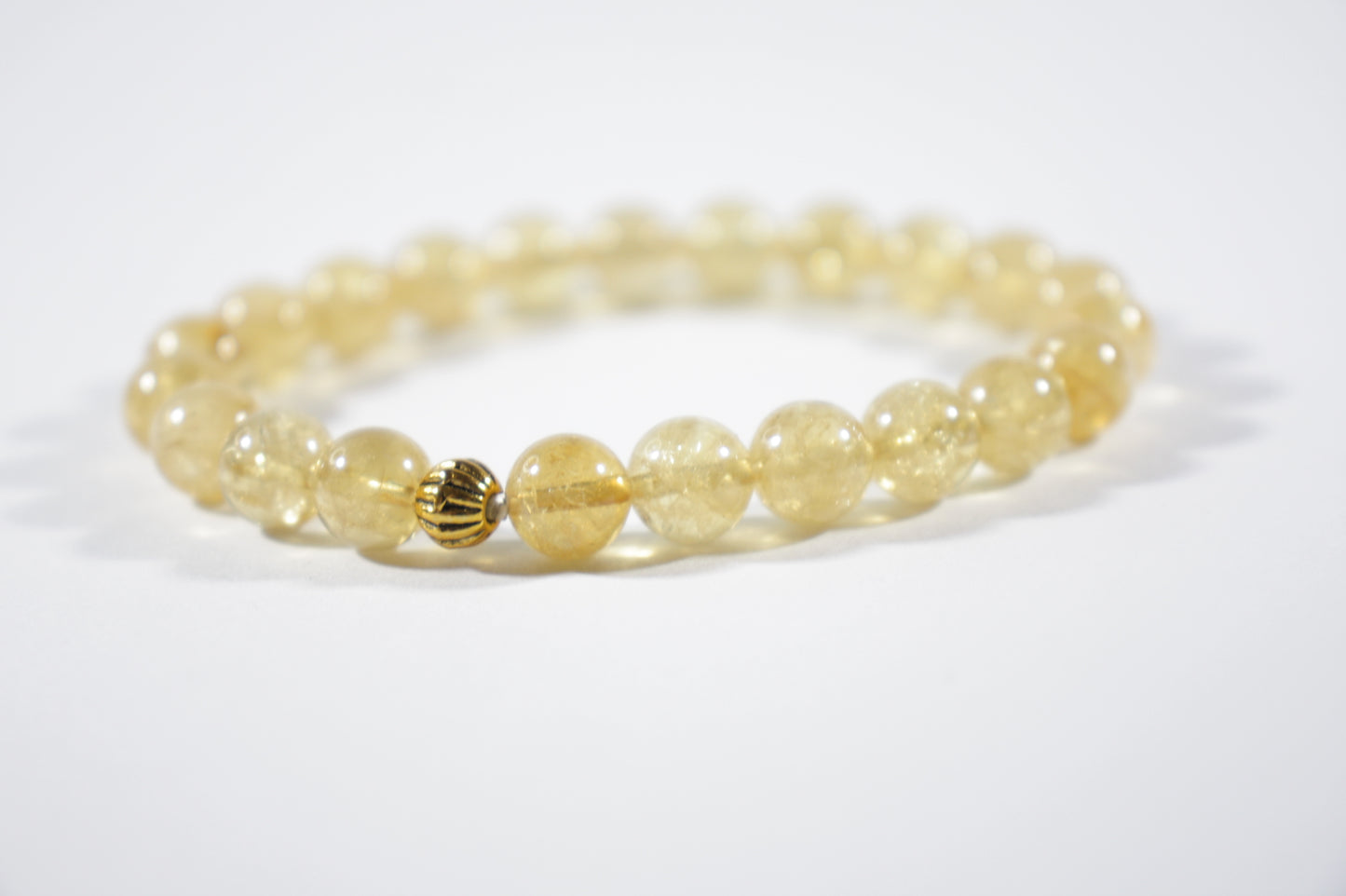 Yellow citrine stretch bracelet with one gold color bead. Keltainen sitriini joustorannekoru yhdellä kullanvärisellä helmellä.