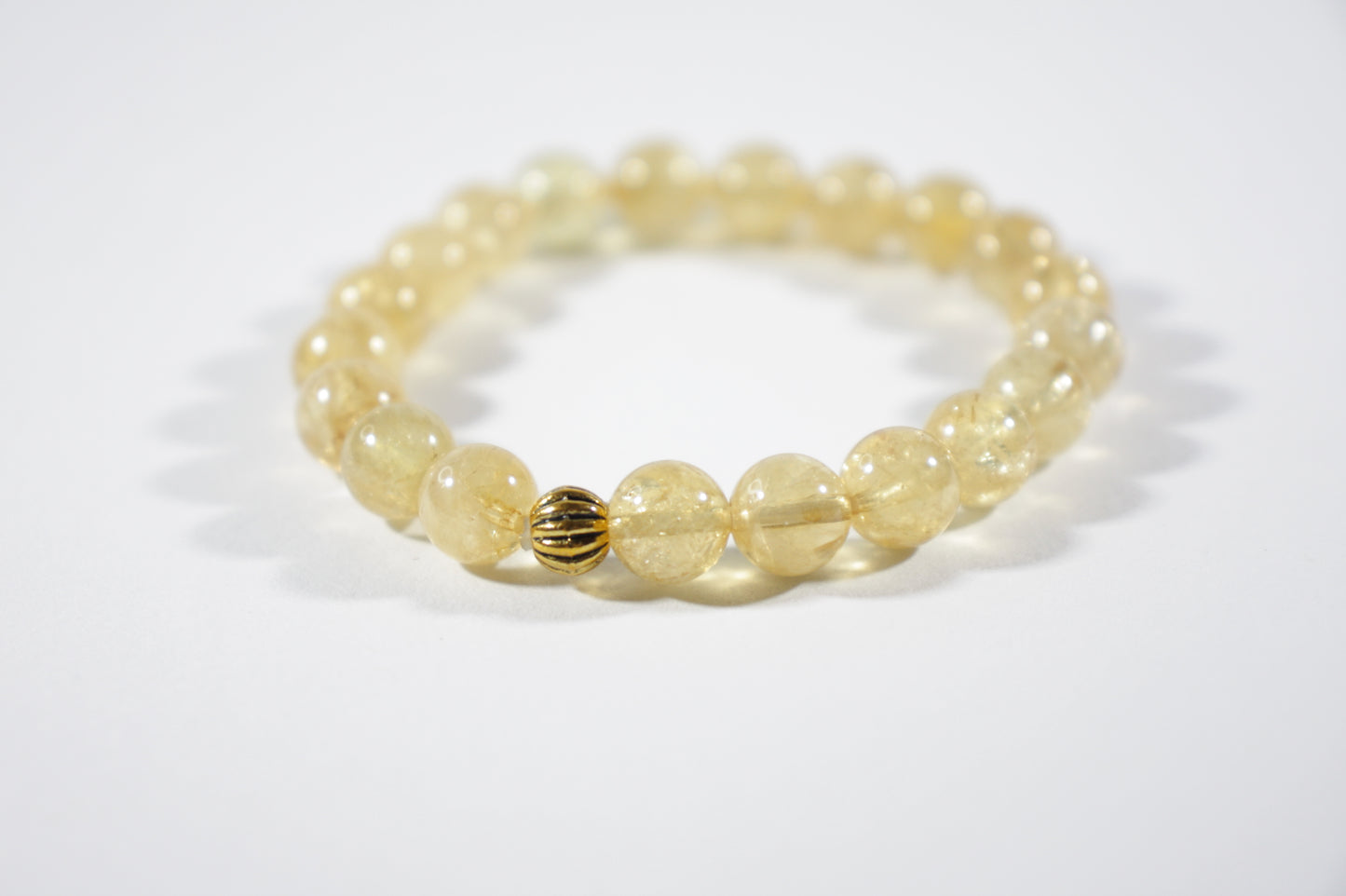 Yellow citrine stretch bracelet with one gold color bead. Keltainen sitriini joustorannekoru yhdellä kullanvärisellä helmellä.