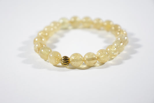 Yellow citrine stretch bracelet with one gold color bead. Keltainen sitriini joustorannekoru yhdellä kullanvärisellä helmellä.