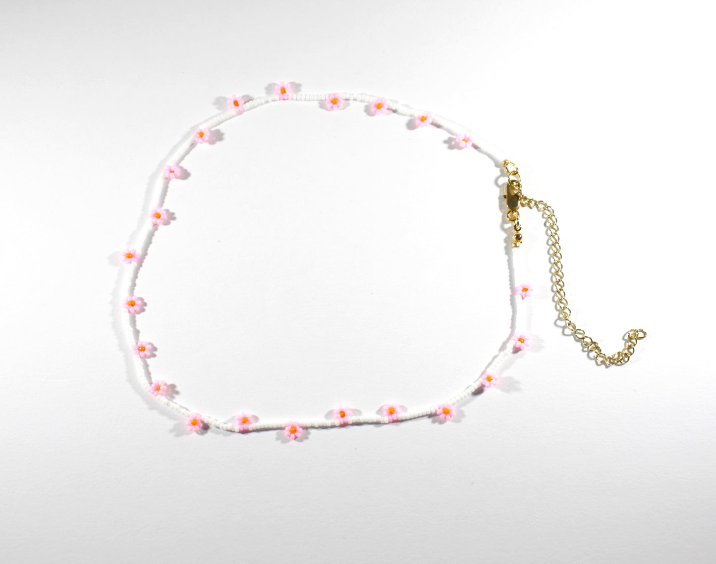 Daisy chain choker necklace white with pink and orange flowers. Päivänkakkara daisy chain choker kaulakoru valkoinen vaaleanpunaisilla kukilla. Kukkien keskusta on oranssi.