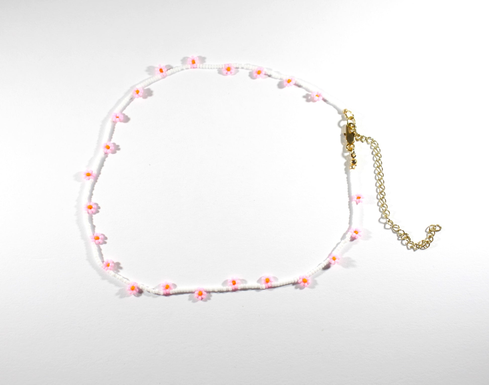 Daisy chain choker necklace white with pink and orange flowers. Päivänkakkara daisy chain choker kaulakoru valkoinen vaaleanpunaisilla kukilla. Kukkien keskusta on oranssi.