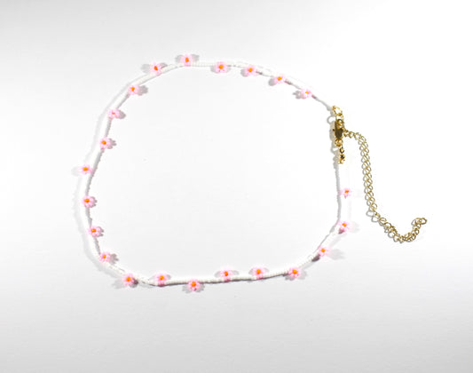 Daisy chain choker necklace white with pink and orange flowers. Päivänkakkara daisy chain choker kaulakoru valkoinen vaaleanpunaisilla kukilla. Kukkien keskusta on oranssi.