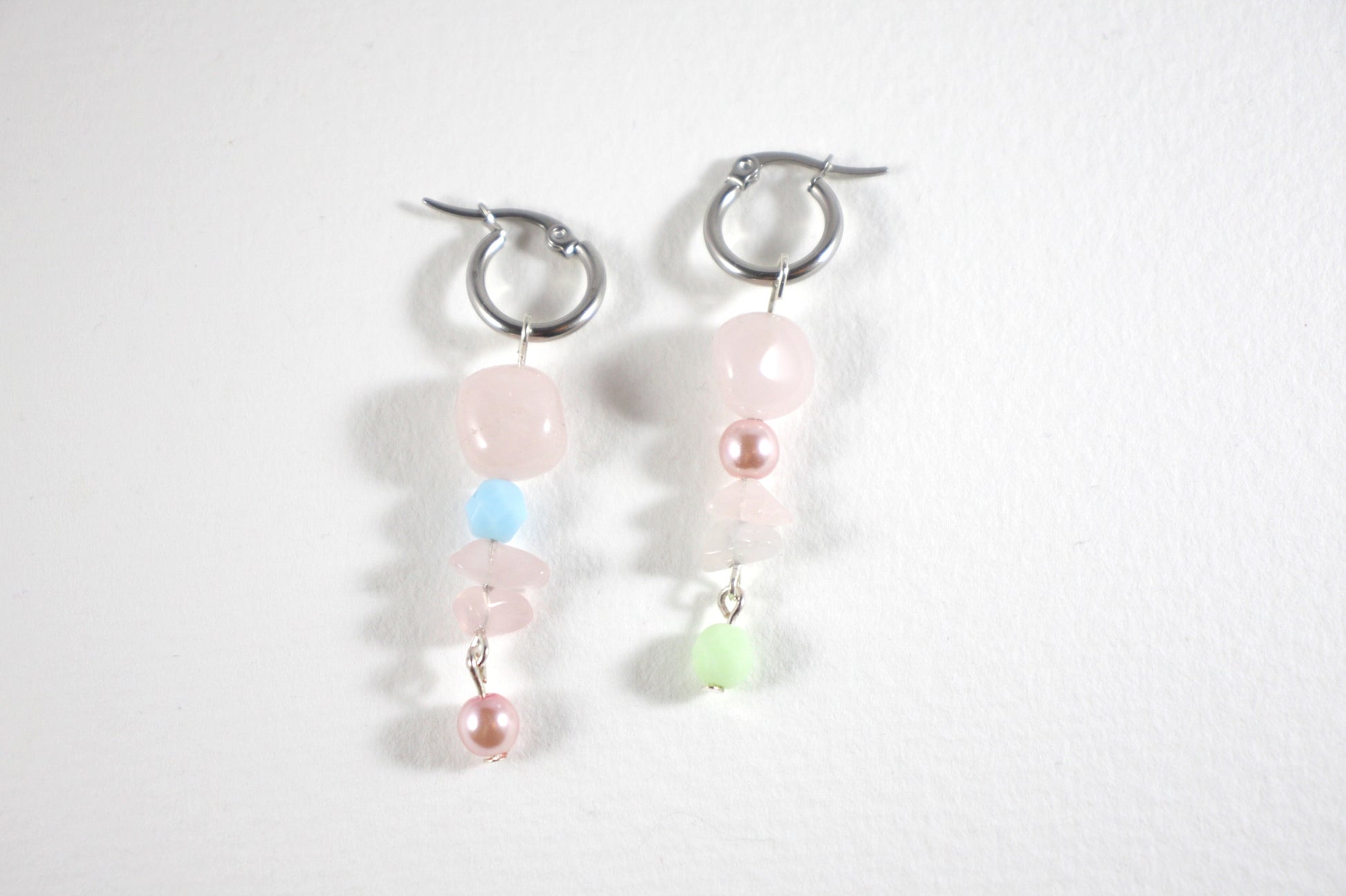 Handmade dangle rose quartz earrings with stainless steel earrings hoops. Käsintehdyt roikkuvat ruusukvartsi korvakorut, joissa on ruostumattomasta teräksestä tehdyt korvakorurenkaat.