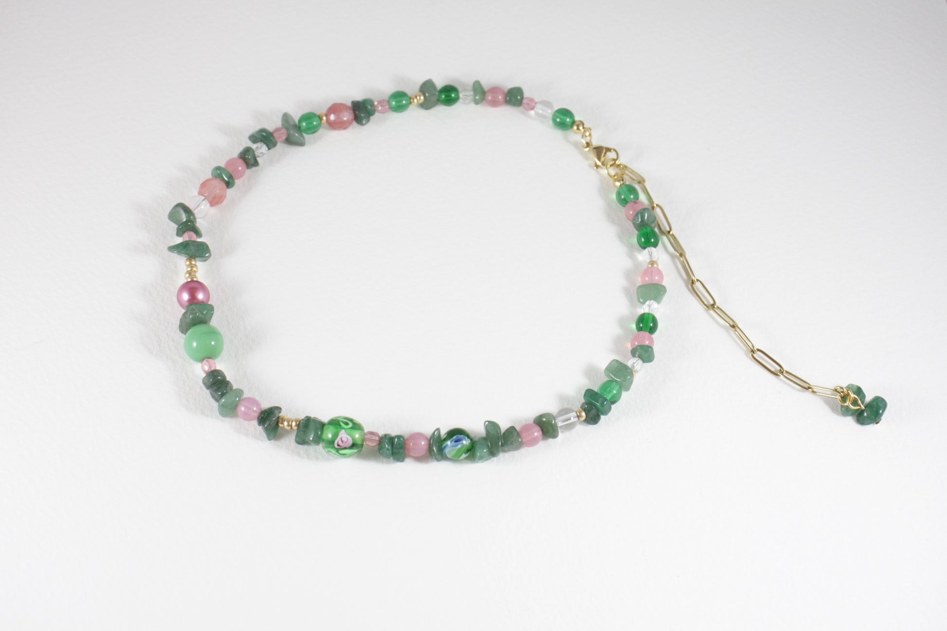 Green aventurine chips choker necklace with pink, gold color, clear and blue different sizes of glass beads. There is also gold color clasp and extension chains. 