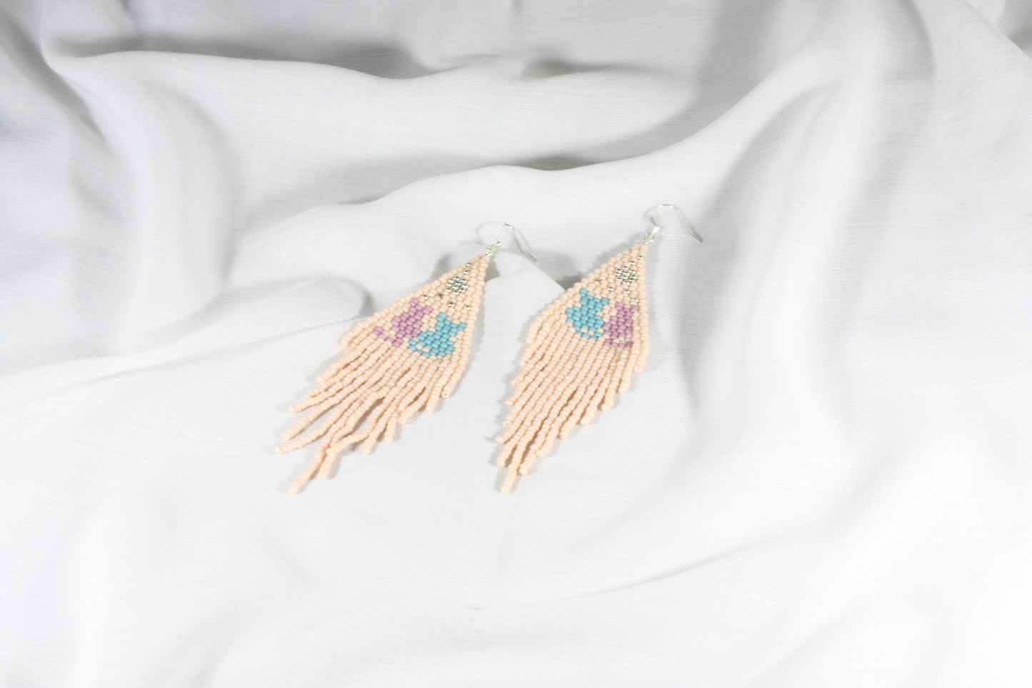 Beaded seed bead earrings light matte pink with cats pattern. Roikkuvat hapsulliset helmikorvakorut vaalea pinkki matta kissa kuviolla.