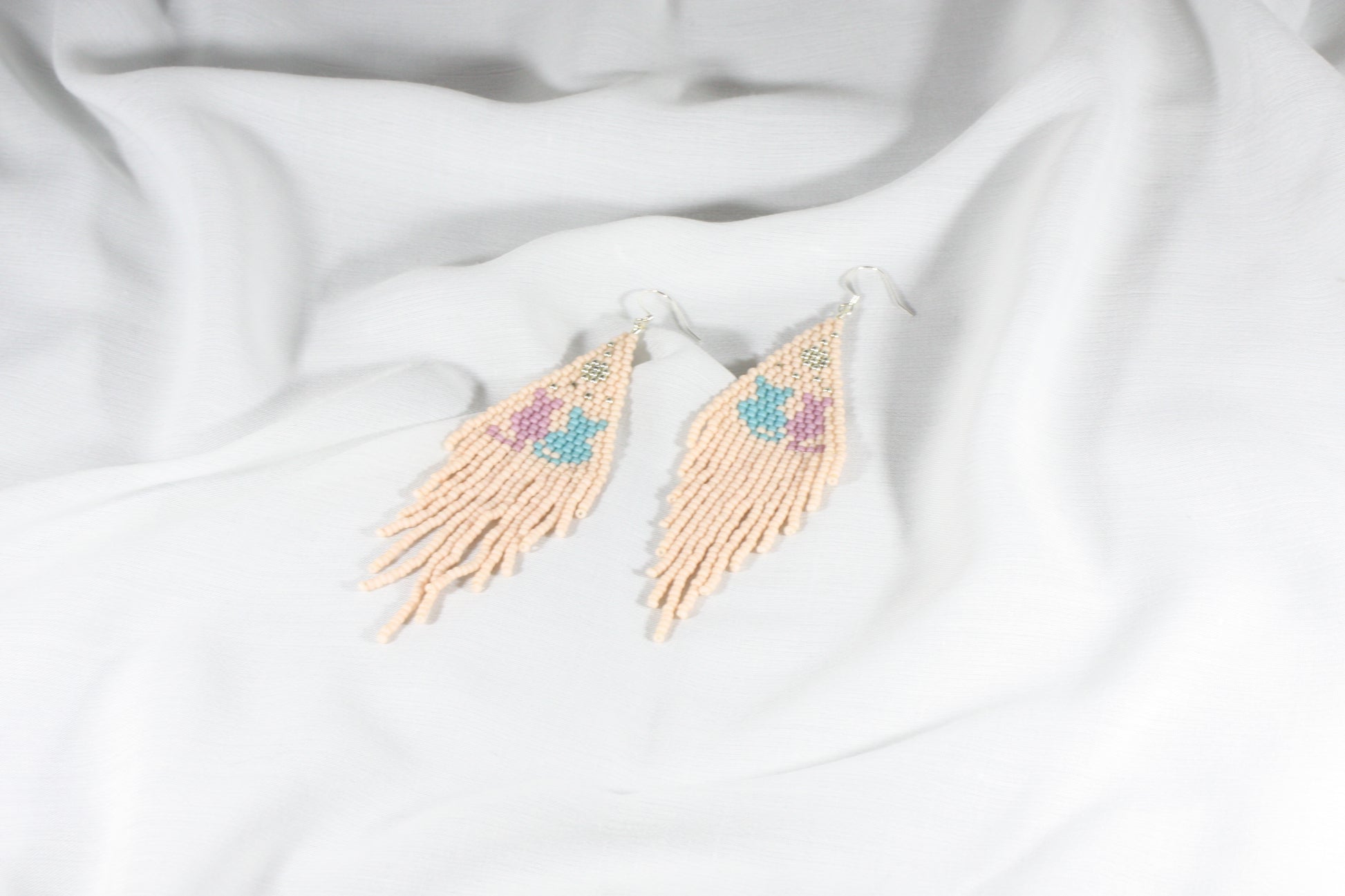 Beaded seed bead earrings light matte pink with cats pattern. Roikkuvat hapsulliset helmikorvakorut vaalea pinkki matta kissa kuviolla.