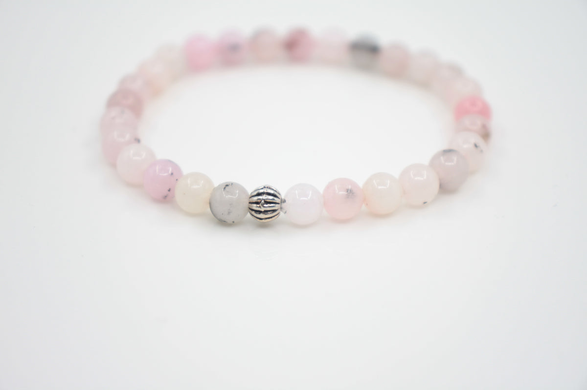 Jaspis kivihelmirannekoru vaaleanpunainen valkoisella alustalla. Pink jasper stone bead bracelet on a white surface. 
