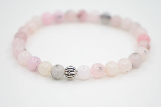 Jaspis kivihelmirannekoru vaaleanpunainen valkoisella alustalla. Pink jasper stone bead bracelet on a white surface. 