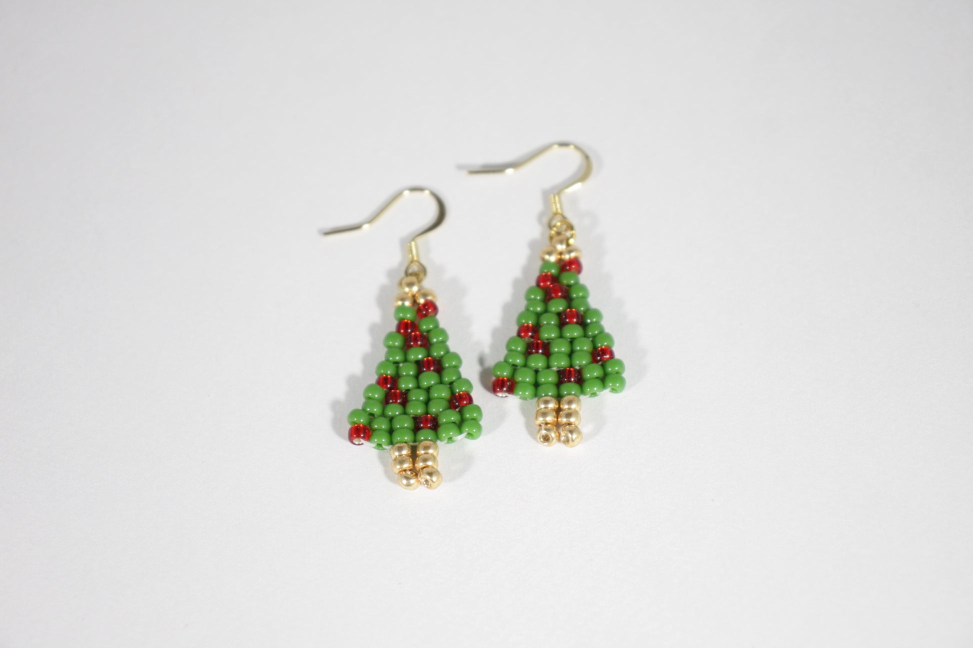 Käsintehdyt joulukuusikorvakorut opaakeilla pienillä lasihelmillä ja kullanvärisillä korvakorukoukuilla. Handmade Christmas Tree earrings with opaque small glass bead and gold color earrings hooks.