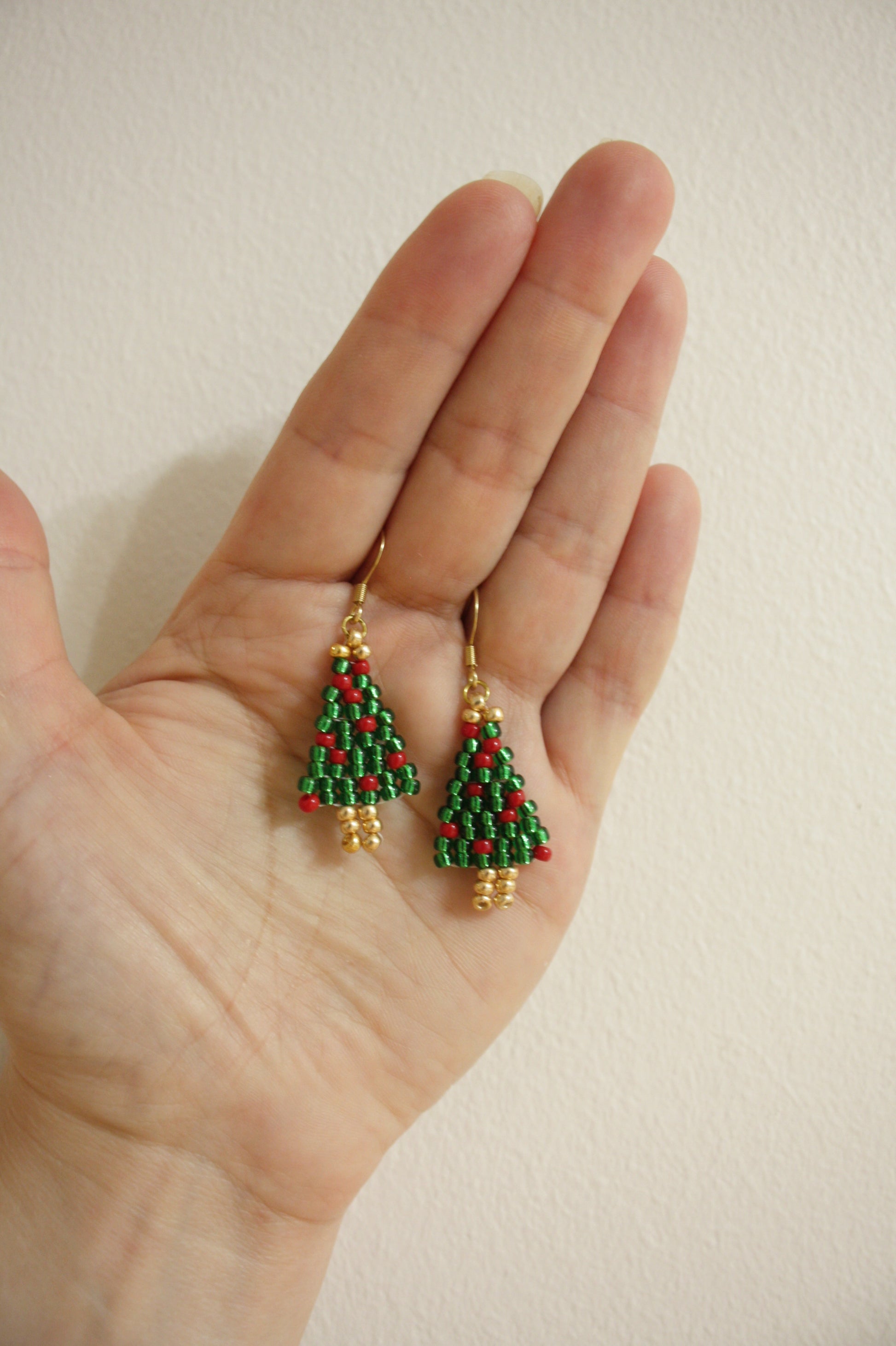 Käsintehdyt joulukuusi helmikorvakorut kimaltelevat vihreät punaisilla koristeilla. Korviksissa on kullanväriset koukut. Handmade green Christmas tree seed bead sparkling earrings with red ornaments. Hooks are gold plated stainless steel.