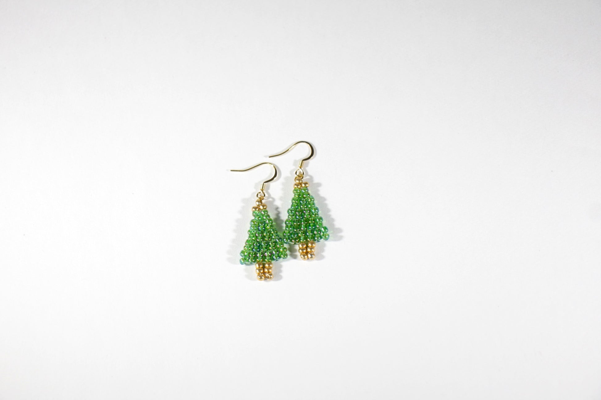 Handmade beaded Christmas Tree earrings from tiny glass beads. Color is reflecting green. Käsintehdyt joulukuusikorvakorut pienistä lasihelmistä. Näissä on kaunis heijastava vihreä sävy. 