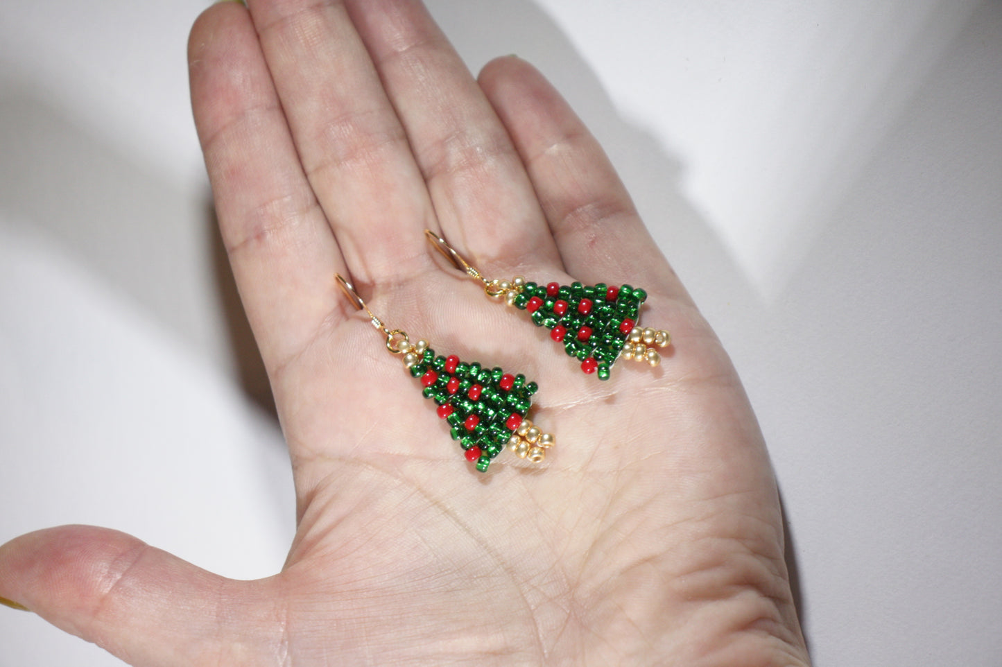 Käsintehdyt joulukuusi helmikorvakorut kimaltelevat vihreät punaisilla koristeilla. Korviksissa on kullanväriset koukut. Handmade green Christmas tree seed bead sparkling earrings with red ornaments. Hooks are gold plated stainless steel.