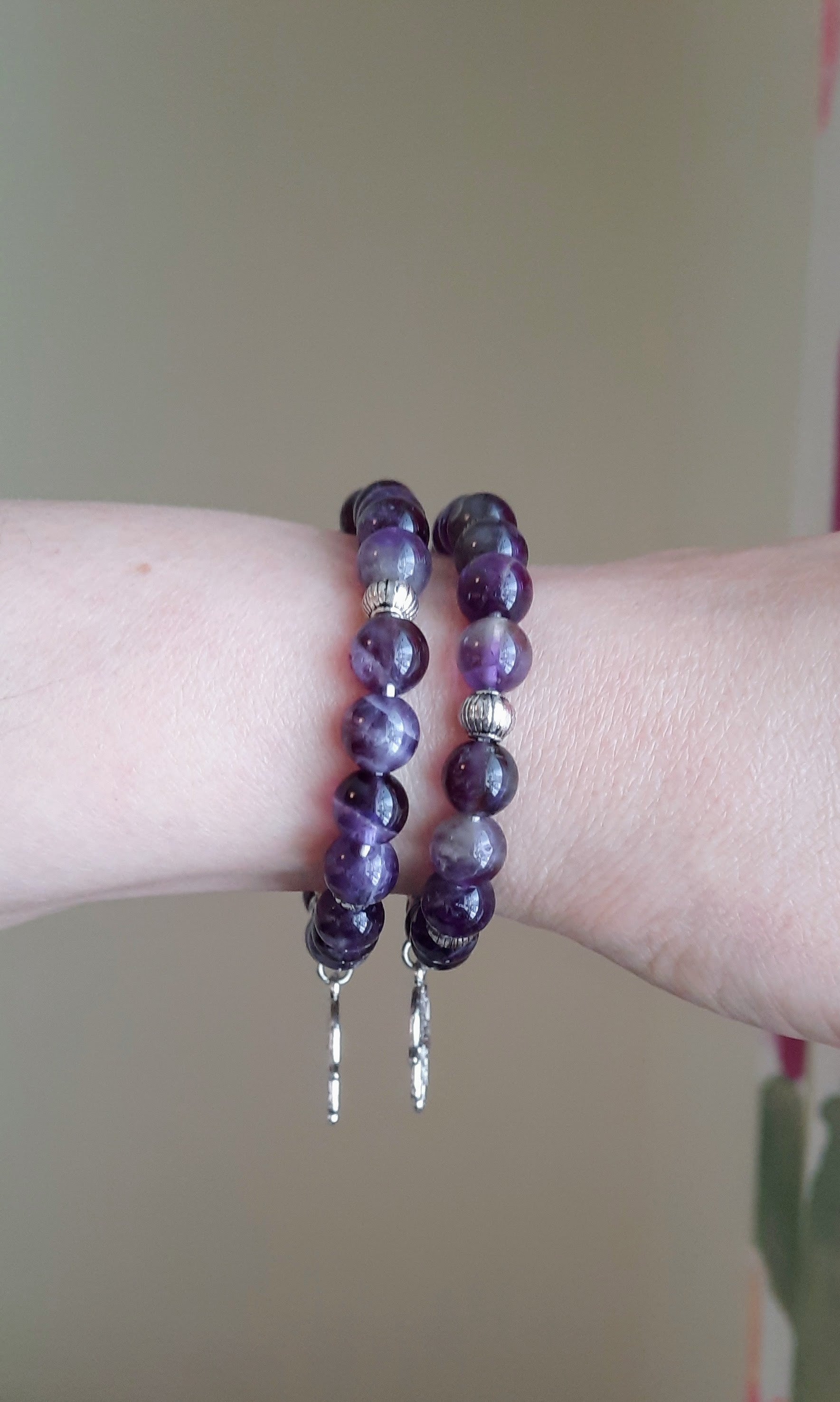 Two amethyst stretchy bracelets with hamsa hand pendant. Kaksi ametisti joustorannekorua hamsa hand riipuksella.