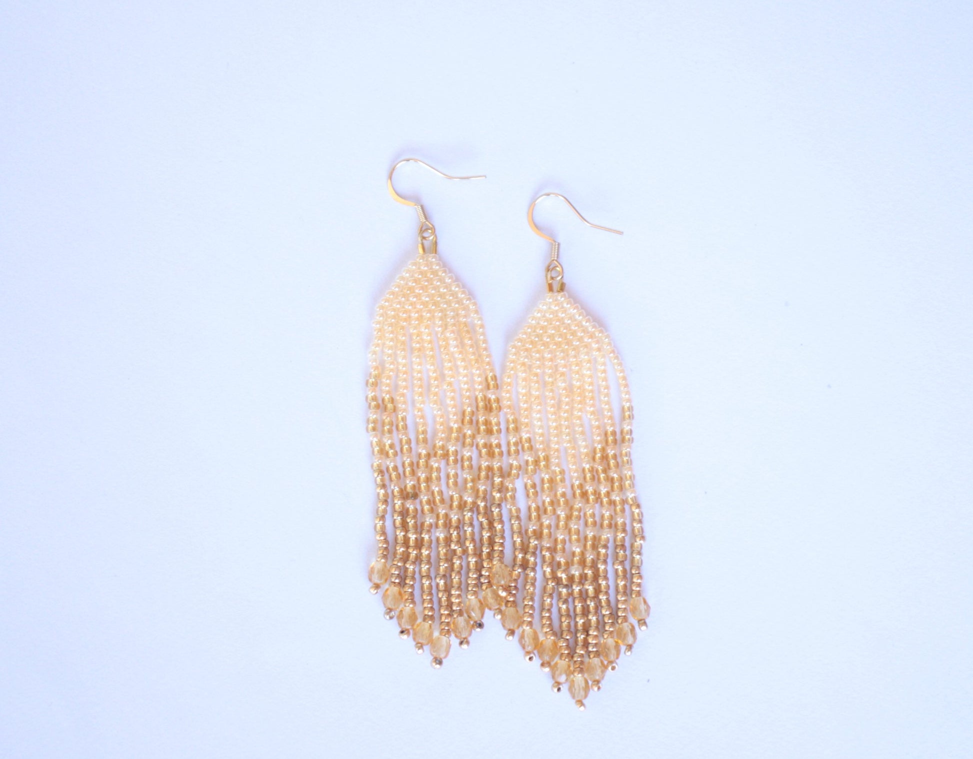 Vaaleankeltaiset roikkuvat hapsulliset helmikorvakorut lasihelmillä. Light yellow seed bead fringe earrings with  class beads.