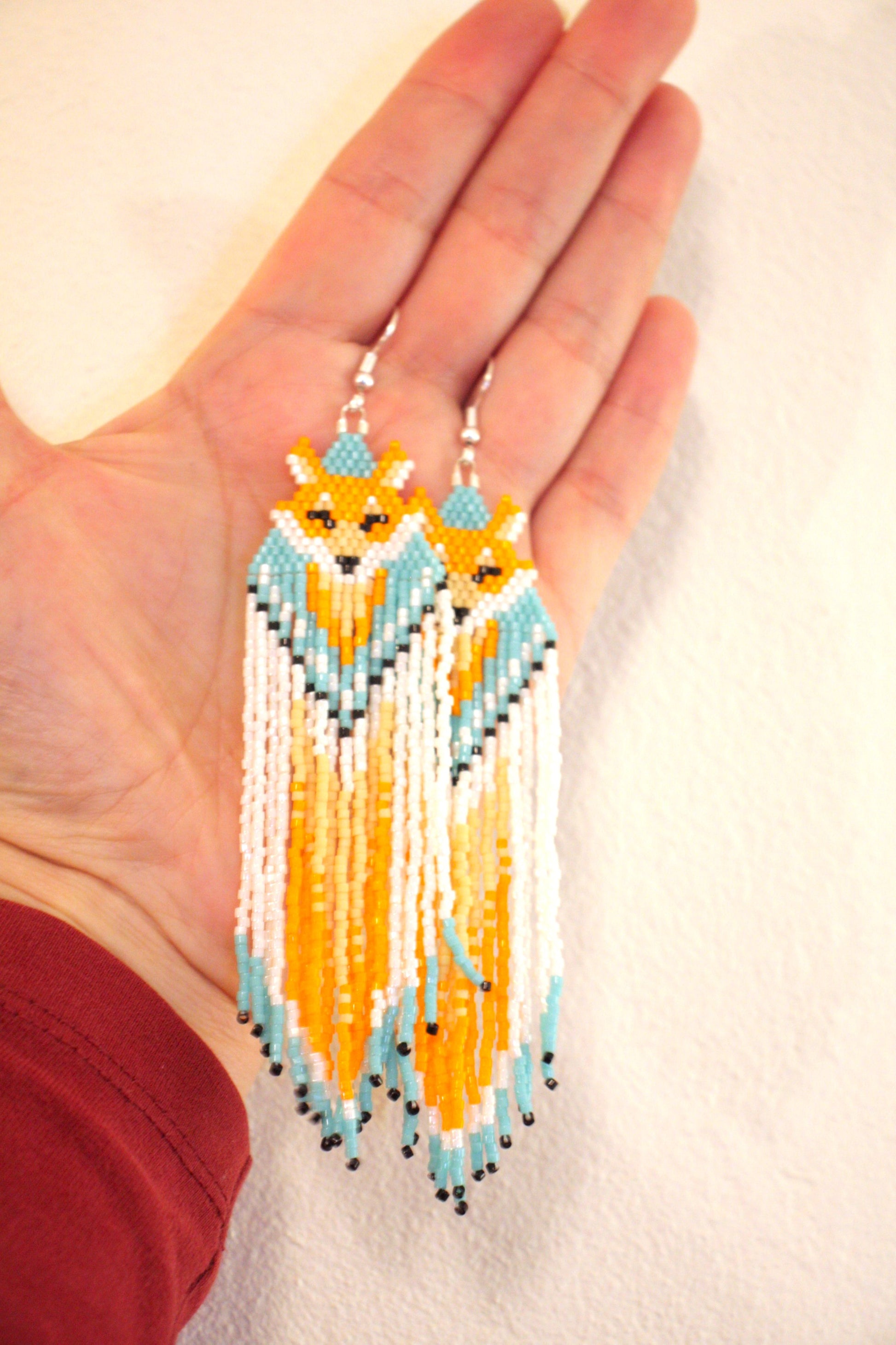 Hapsulliset lasihelmikorvakorut ketut värinä oranssi-siniturkoosi. Seed bead fringe earrings foxes, color orange and blueturquoise.