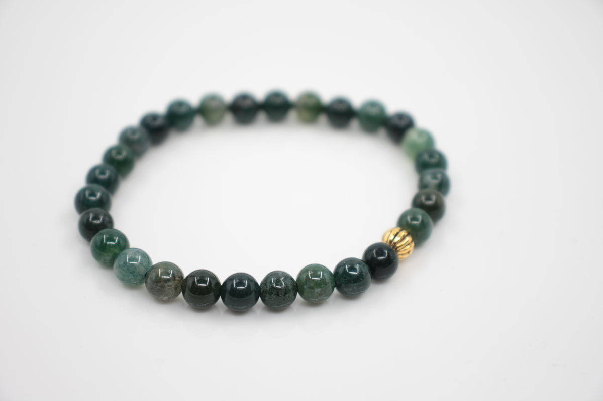 Vihreä sammalakaatti rannekoru kullanvärisellä metallihelmellä. Tausta on valkoinen. Green moss agate bracelet with gold color metal bead. Background is white.