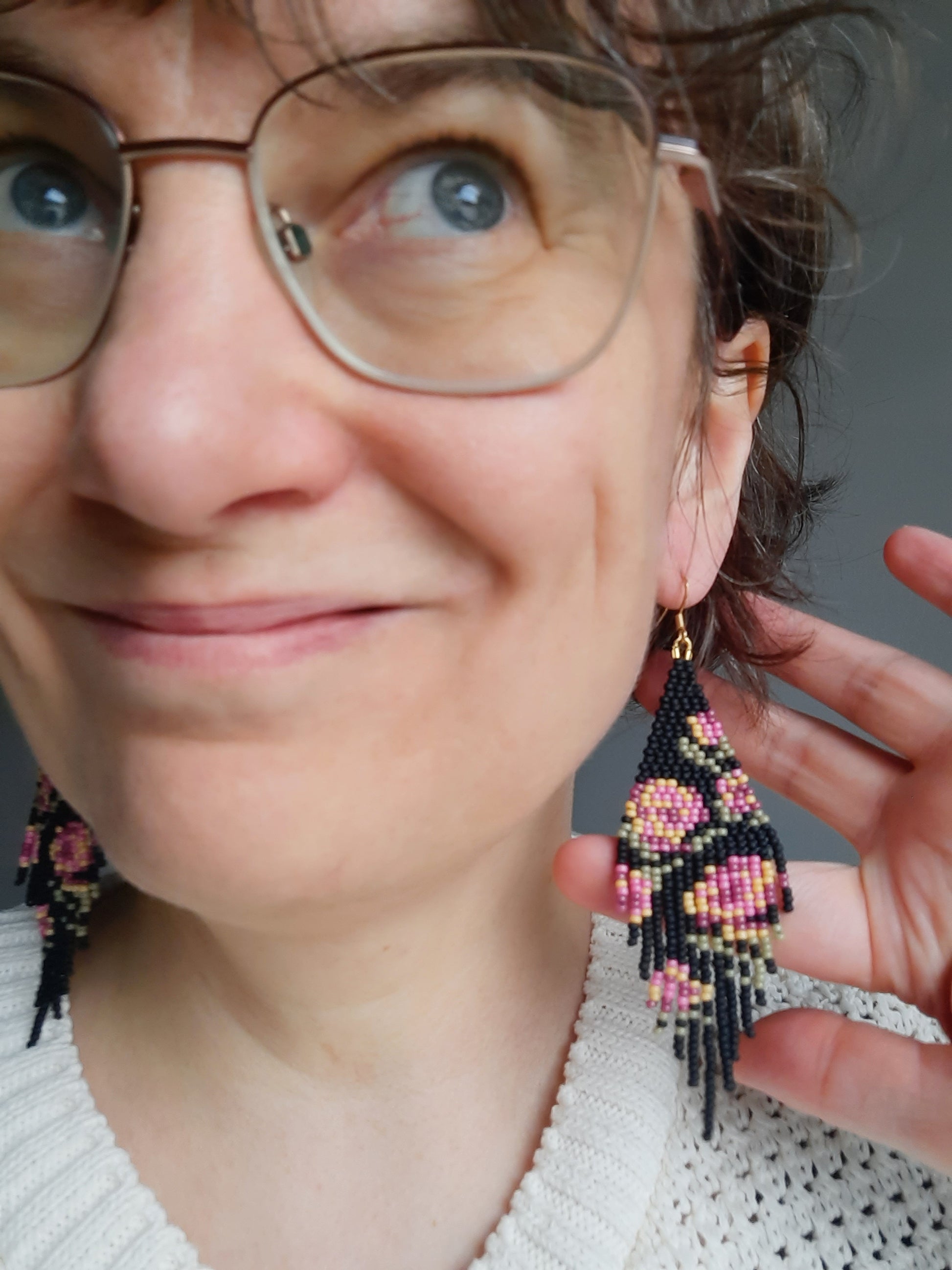 Long colorful seed bead fringe earrings. Base color is matte black and these earrings has pink-yellow rose pattern. Pitkä roikkuvat helmikorvakorut hapsuilla. Näissä korviksissa on matta musta perusväri ja kuviona on pinkin ja keltaisen sävyisiä ruusuja.