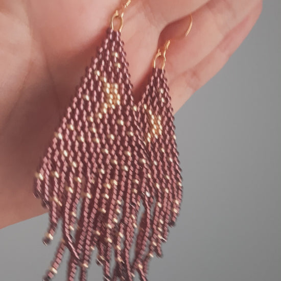 Seed bead fringe earrings with moon and stars pattern. Base color is dark amethyst and moon and star are gold color. Roikkuvat hapsulliset helmikorvakorut, joissa kuviona on kuu ja tähdet. Pohjavärinä on tumma ametisti ja kuu tähdet ovat kullan värisiä.