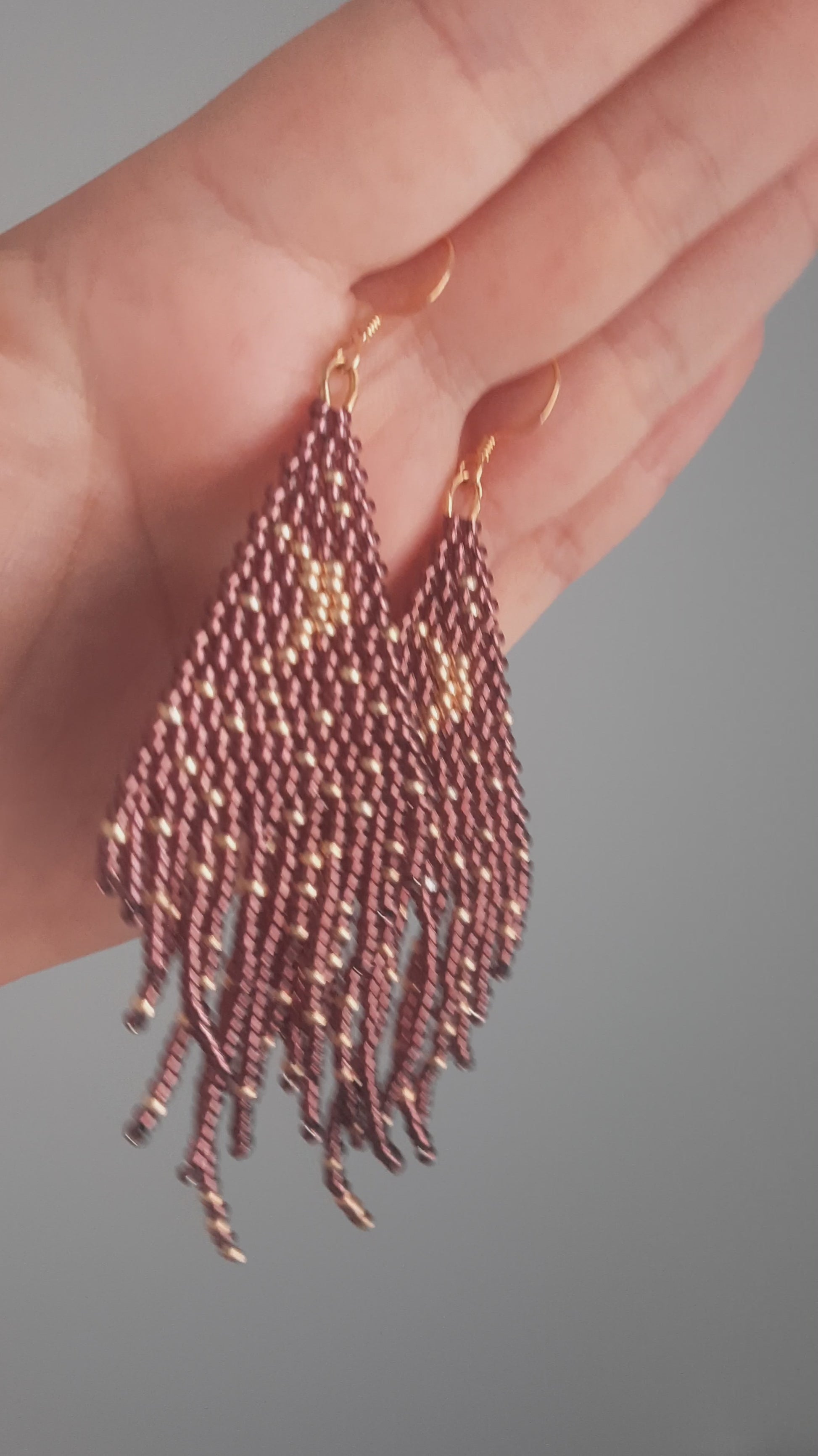 Seed bead fringe earrings with moon and stars pattern. Base color is dark amethyst and moon and star are gold color. Roikkuvat hapsulliset helmikorvakorut, joissa kuviona on kuu ja tähdet. Pohjavärinä on tumma ametisti ja kuu tähdet ovat kullan värisiä.