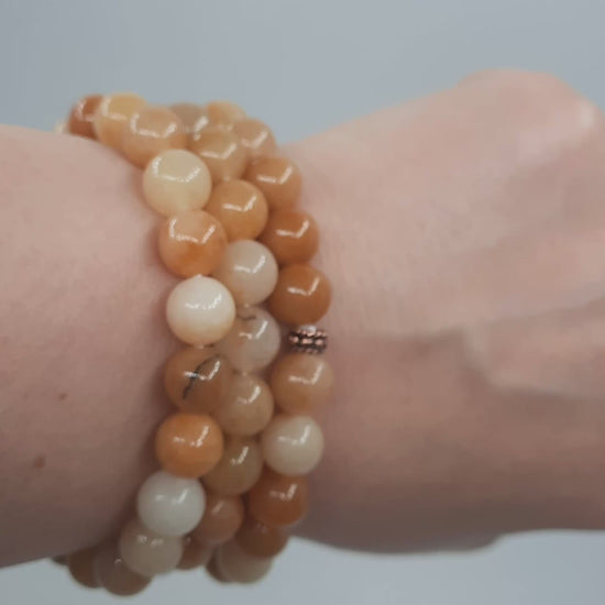 Kolme keltainen jade rannekorua esittelyssä kädessä. Three yellow jade bracelets in the spotlight on the hand.