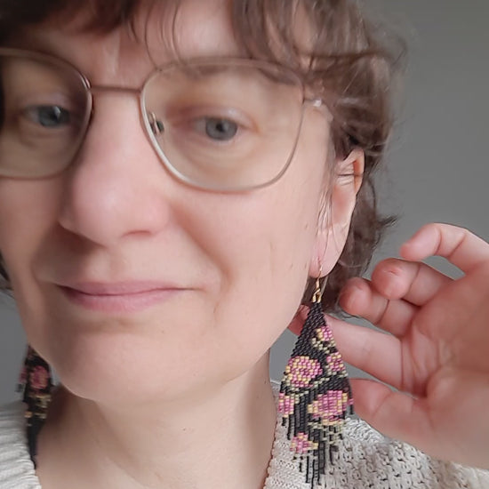 Long colorful seed bead fringe earrings. Base color is matte black and these earrings has pink-yellow rose pattern. Pitkä roikkuvat helmikorvakorut hapsuilla. Näissä korviksissa on matta musta perusväri ja kuviona on pinkin ja keltaisen sävyisiä ruusuja.