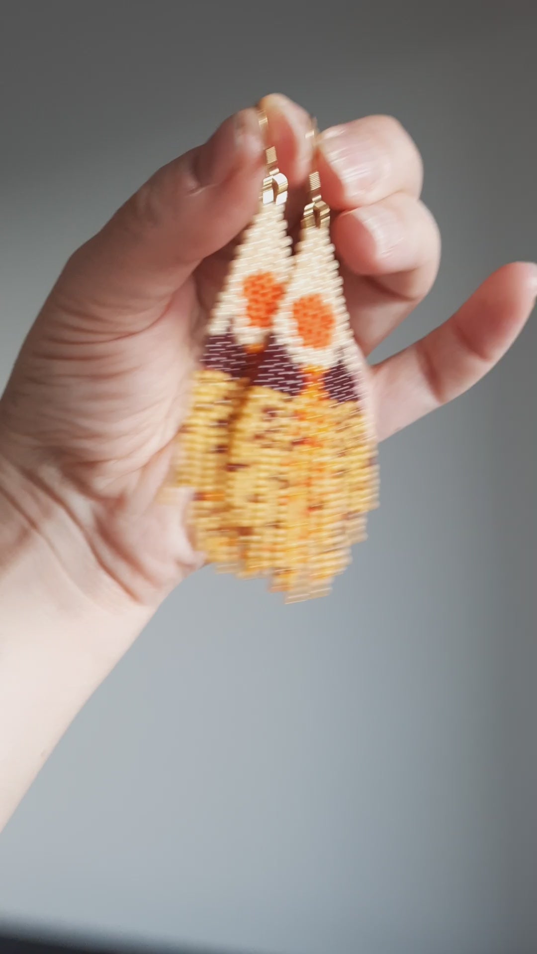 Seed bead fringe earrings with scenery pattern. Colors are brown, yellow and orange shades. Roikkuvat hapsukorvakorut pienistä lasihelmistä. Kuviona näissä korvakoruina on maisema ja värit loistavat keltaisen, ruskean ja oranssin sävyissä.
