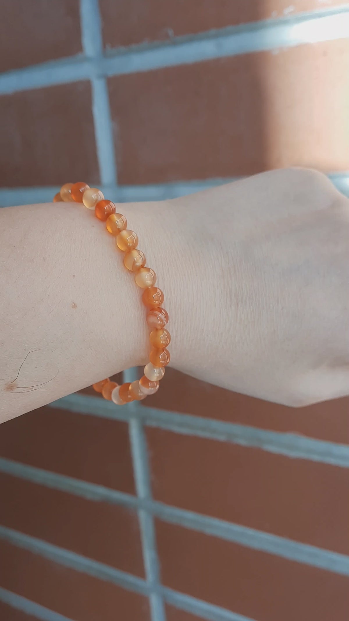 Karneoli rannekoru ranteessa. Carnelian bracelet on a wrist.