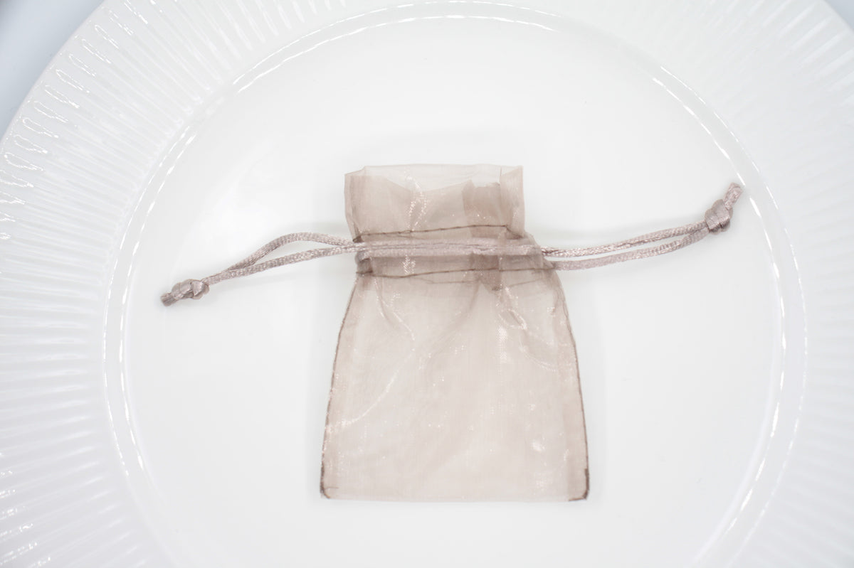 Organza pussi rannekorulle valkoisella alustalla. Organza bag for bracelet on white background. 